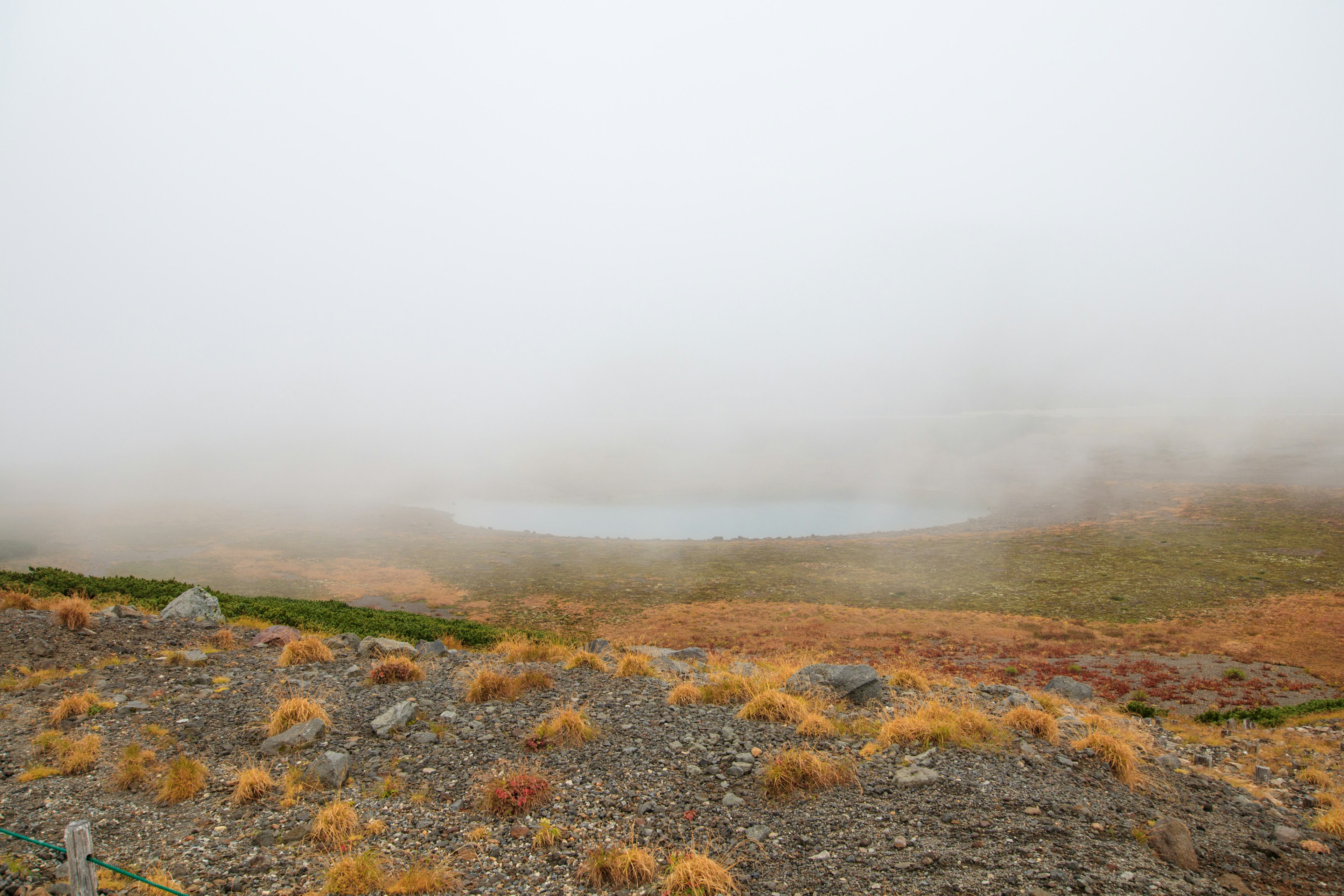 Paysage montagneux brumeux avec un petit étang