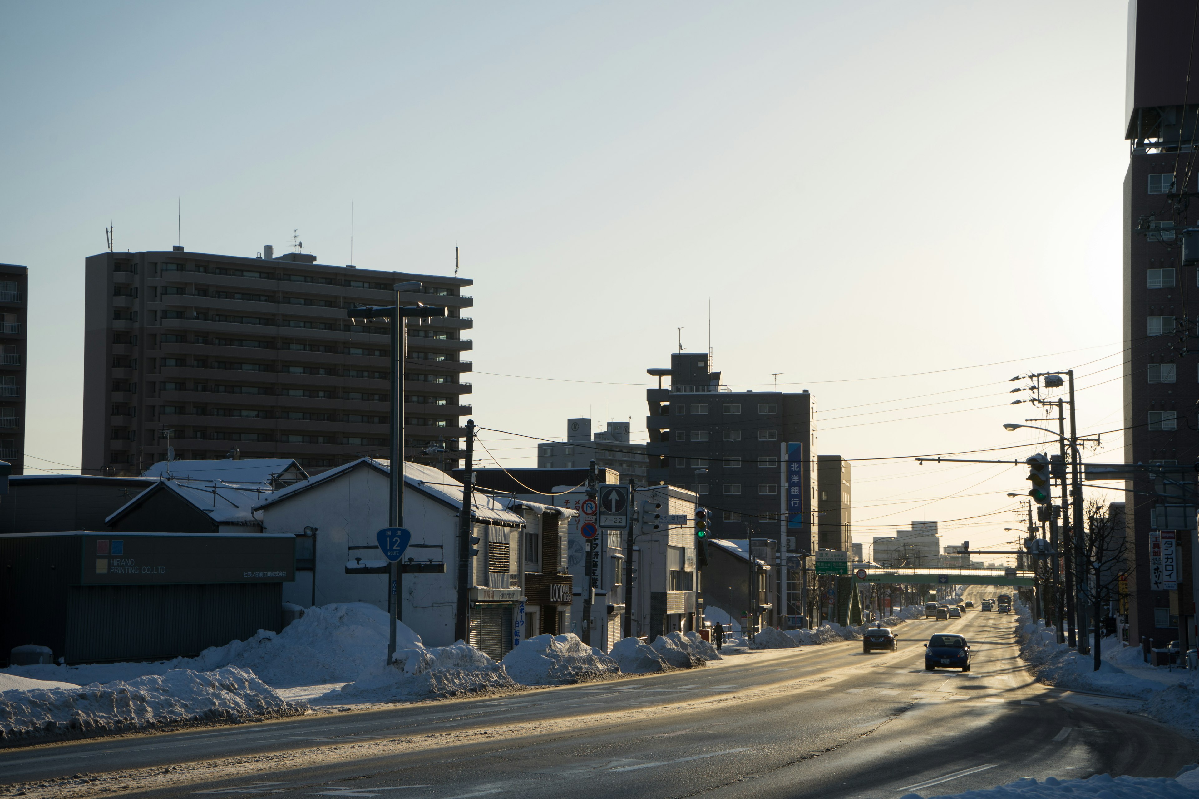 Snow-covered street with buildings and winter sky