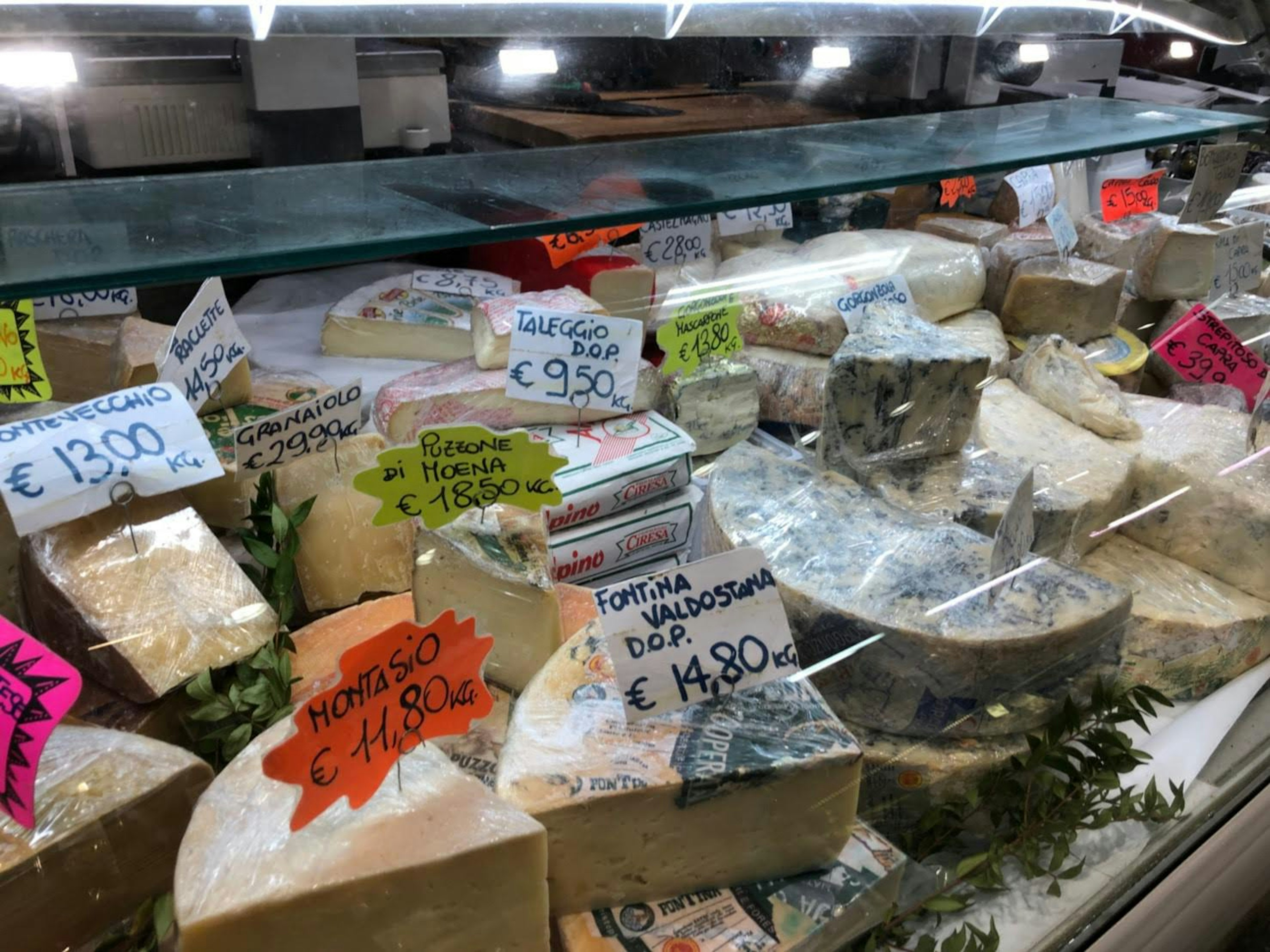 Cheese display case featuring a variety of cheeses with price tags