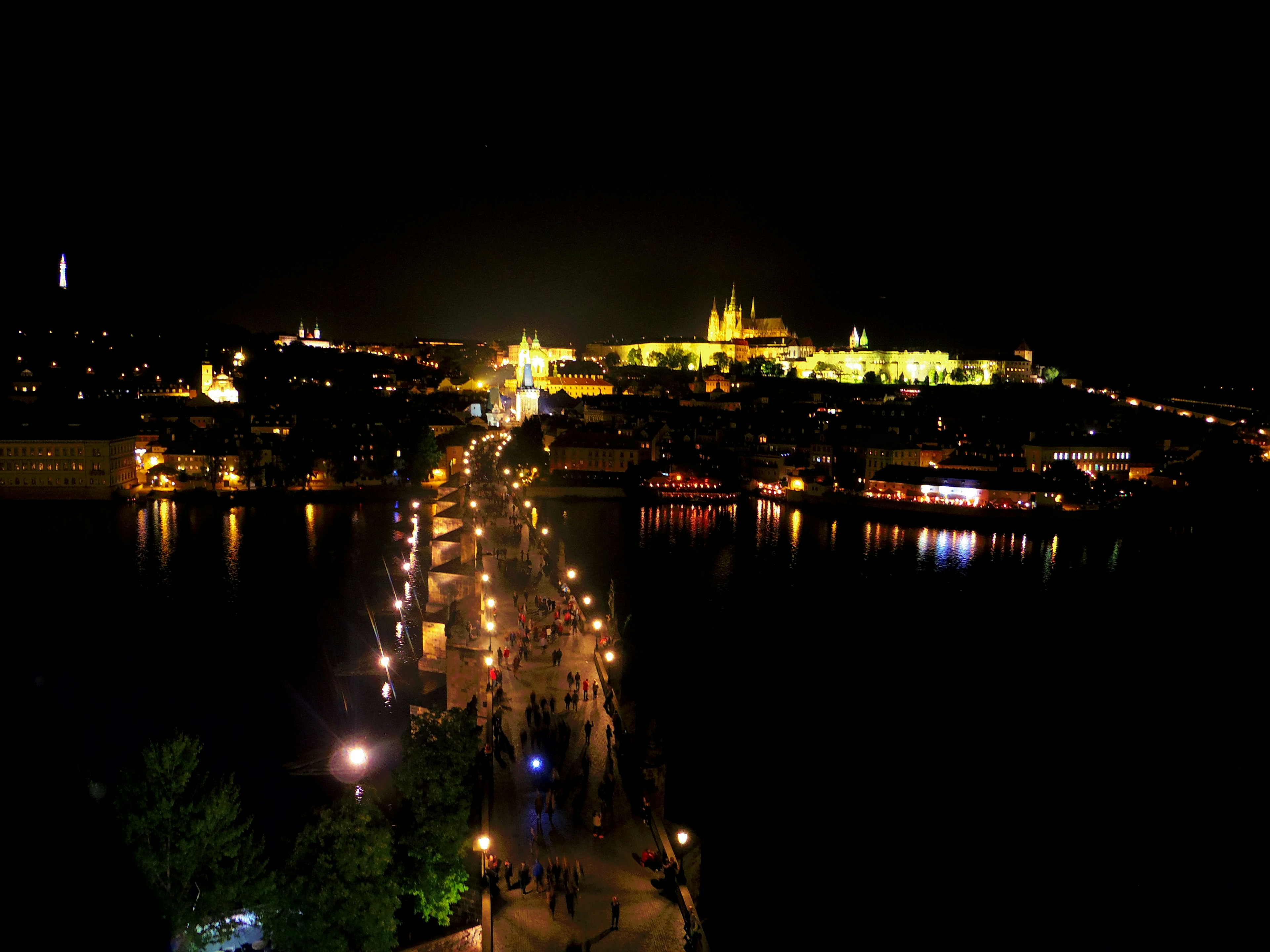 Vista nocturna de Praga con edificios iluminados y río