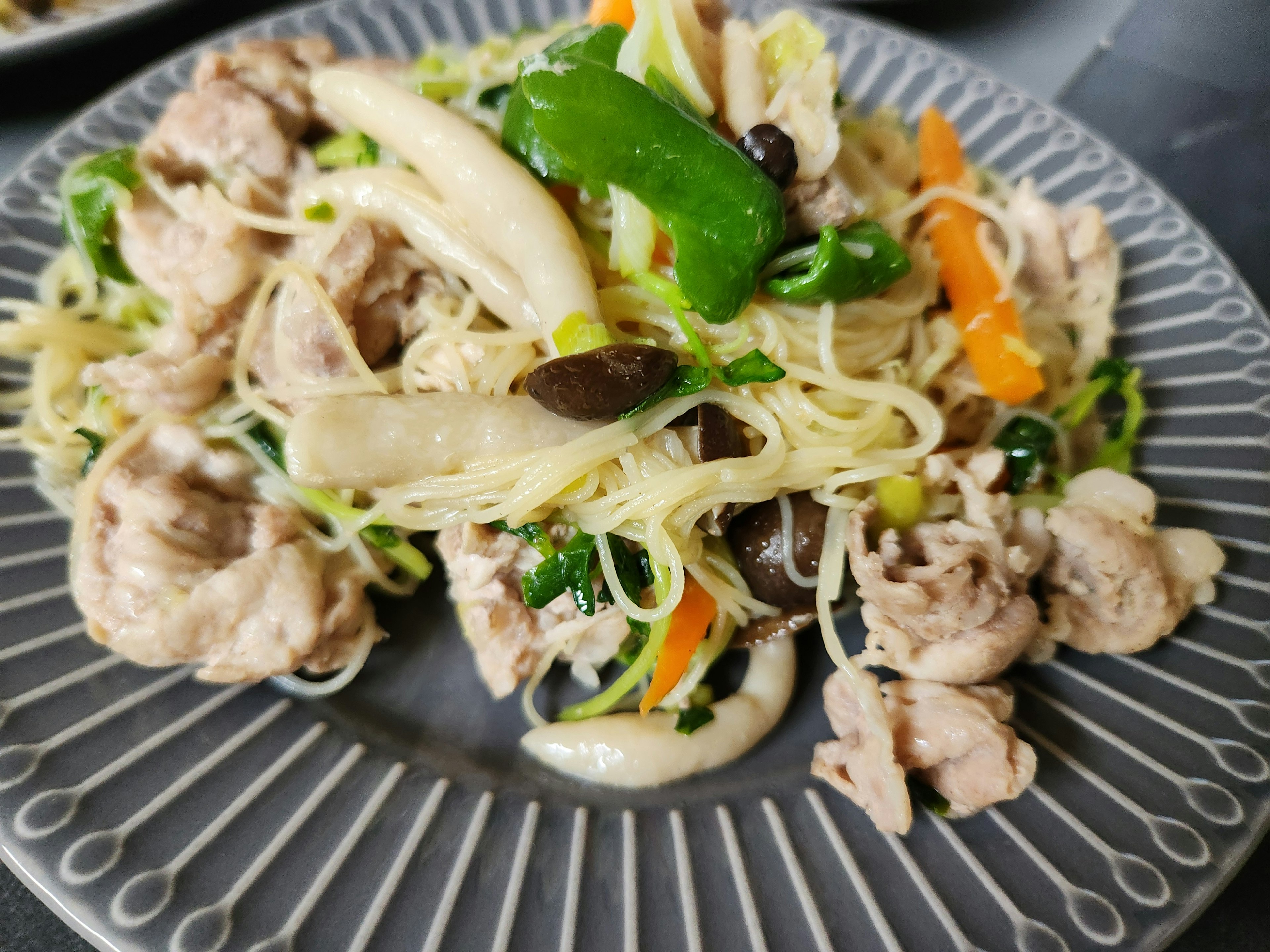 皿に盛られた鶏肉と野菜の炒め物と春雨の料理