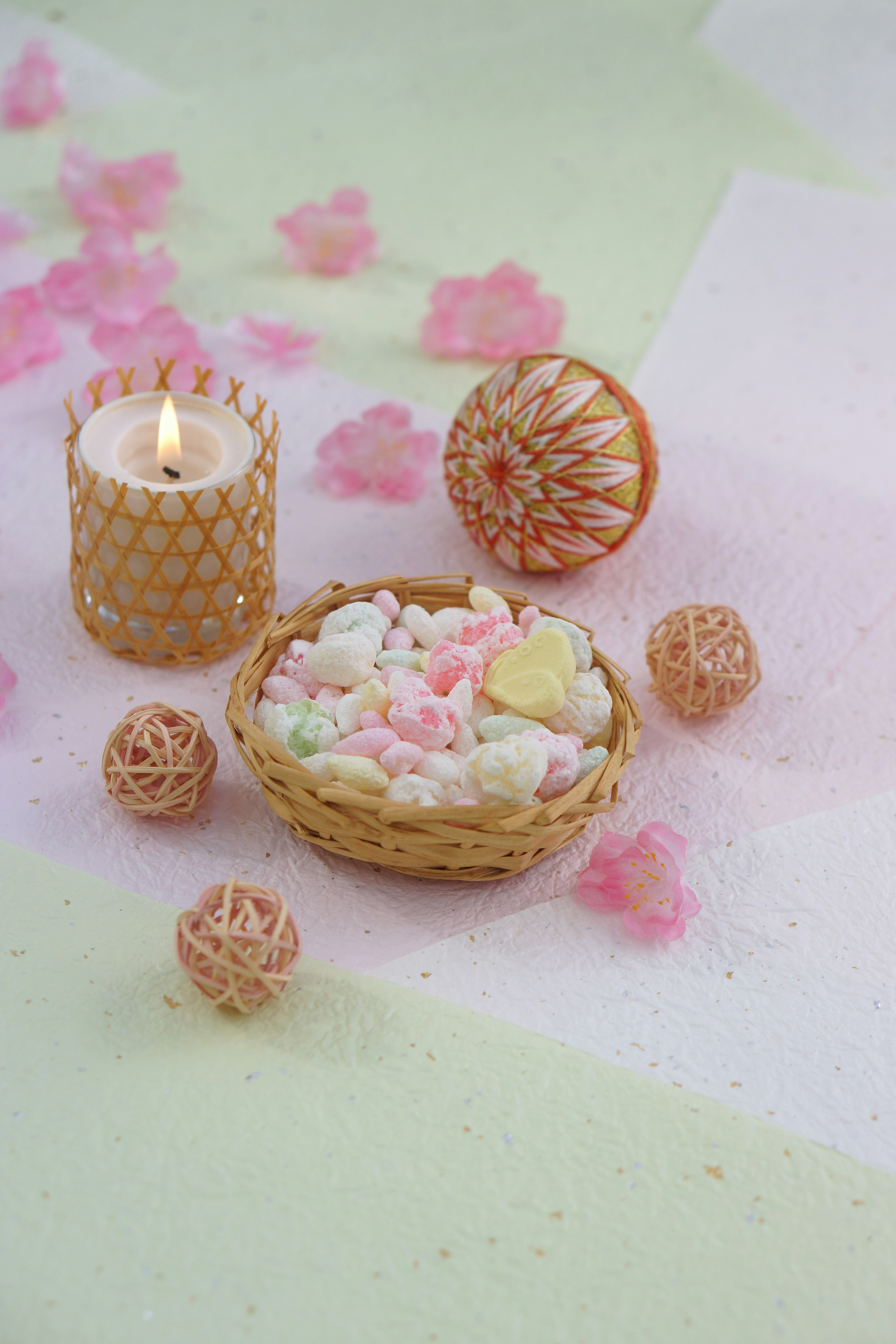 Decorative arrangement with colorful candle and flower petals