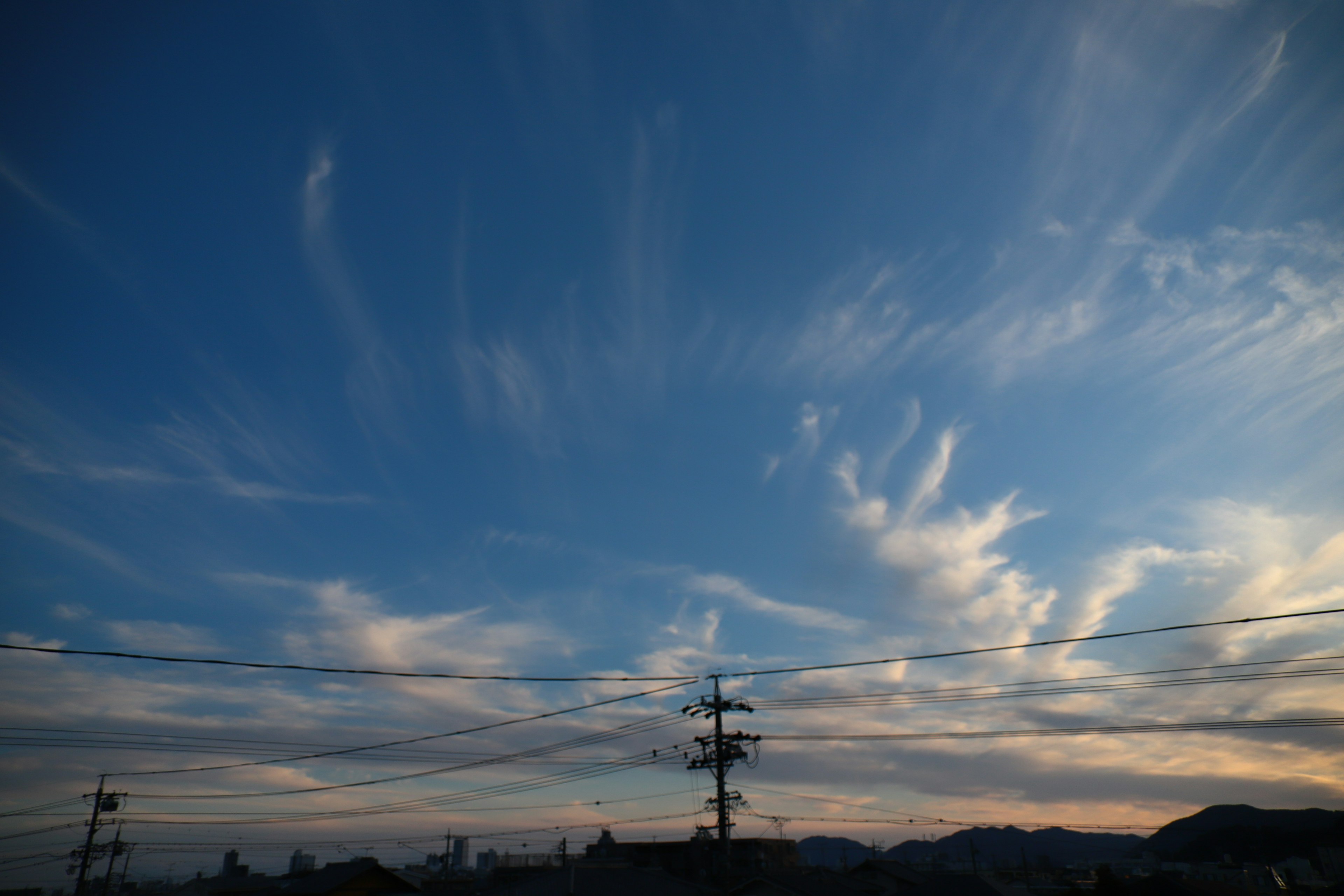 青い空に広がる雲と山のシルエット