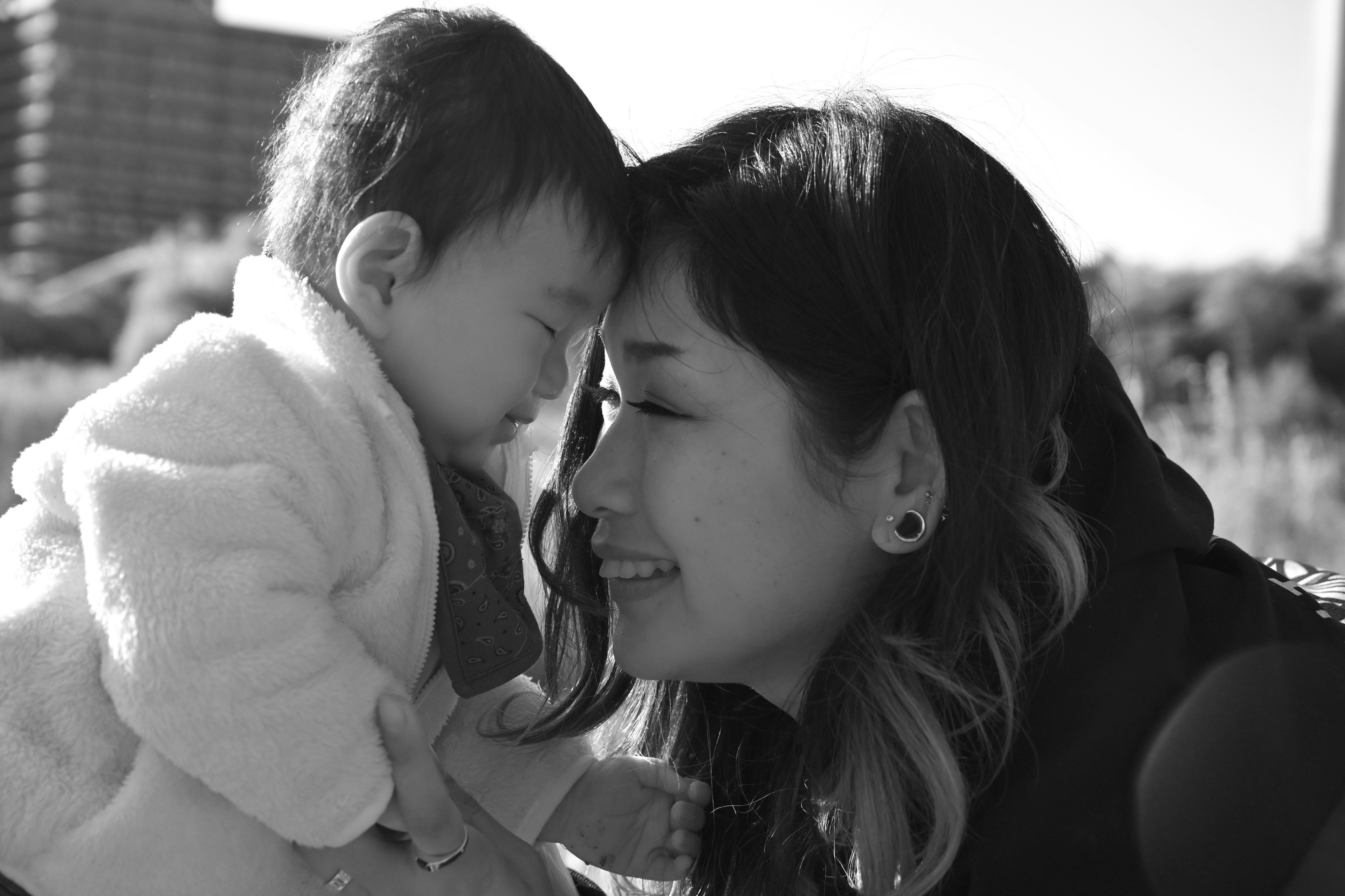 Photo en noir et blanc d'un bébé et d'une mère partageant un moment joyeux face à face