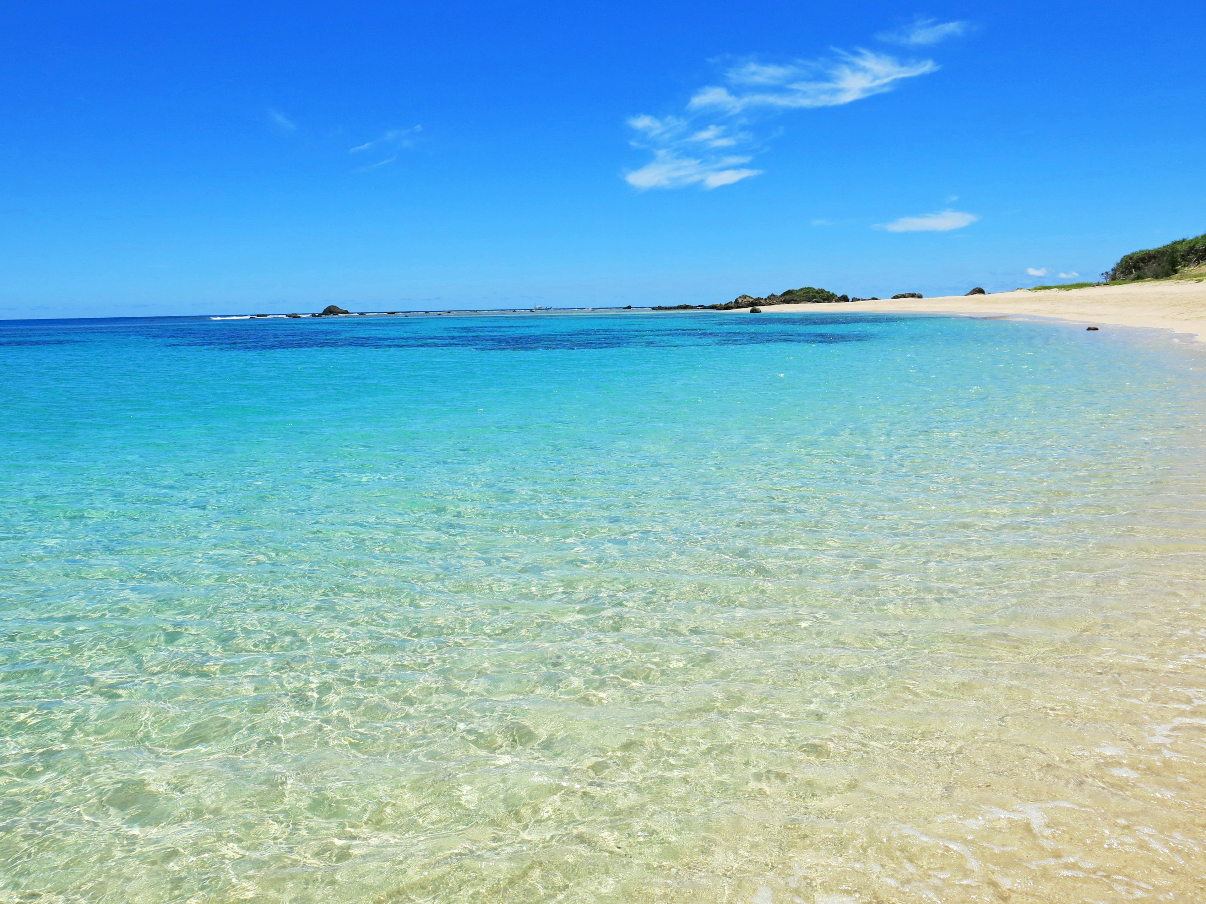 Scène de plage magnifique avec une eau bleue claire et un rivage de sable blanc