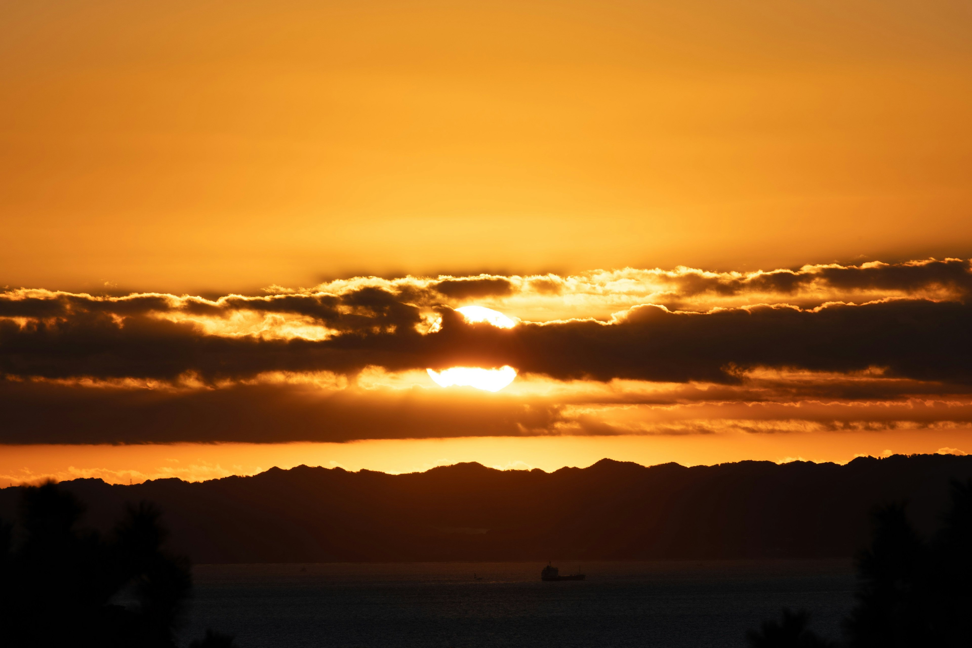 美しい夕焼けの空に沈む太陽と雲のシルエット