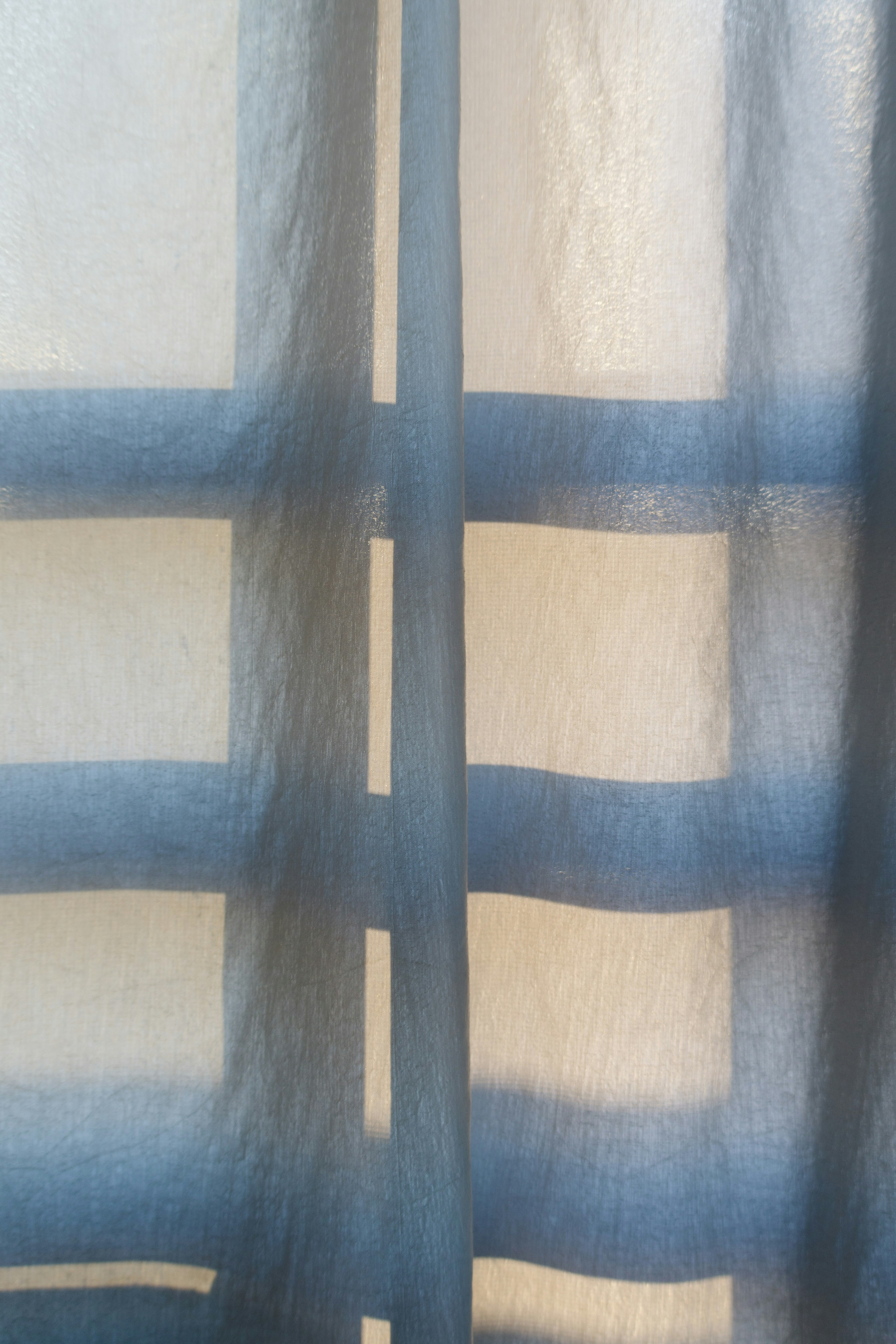 Soft light behind a blue striped curtain