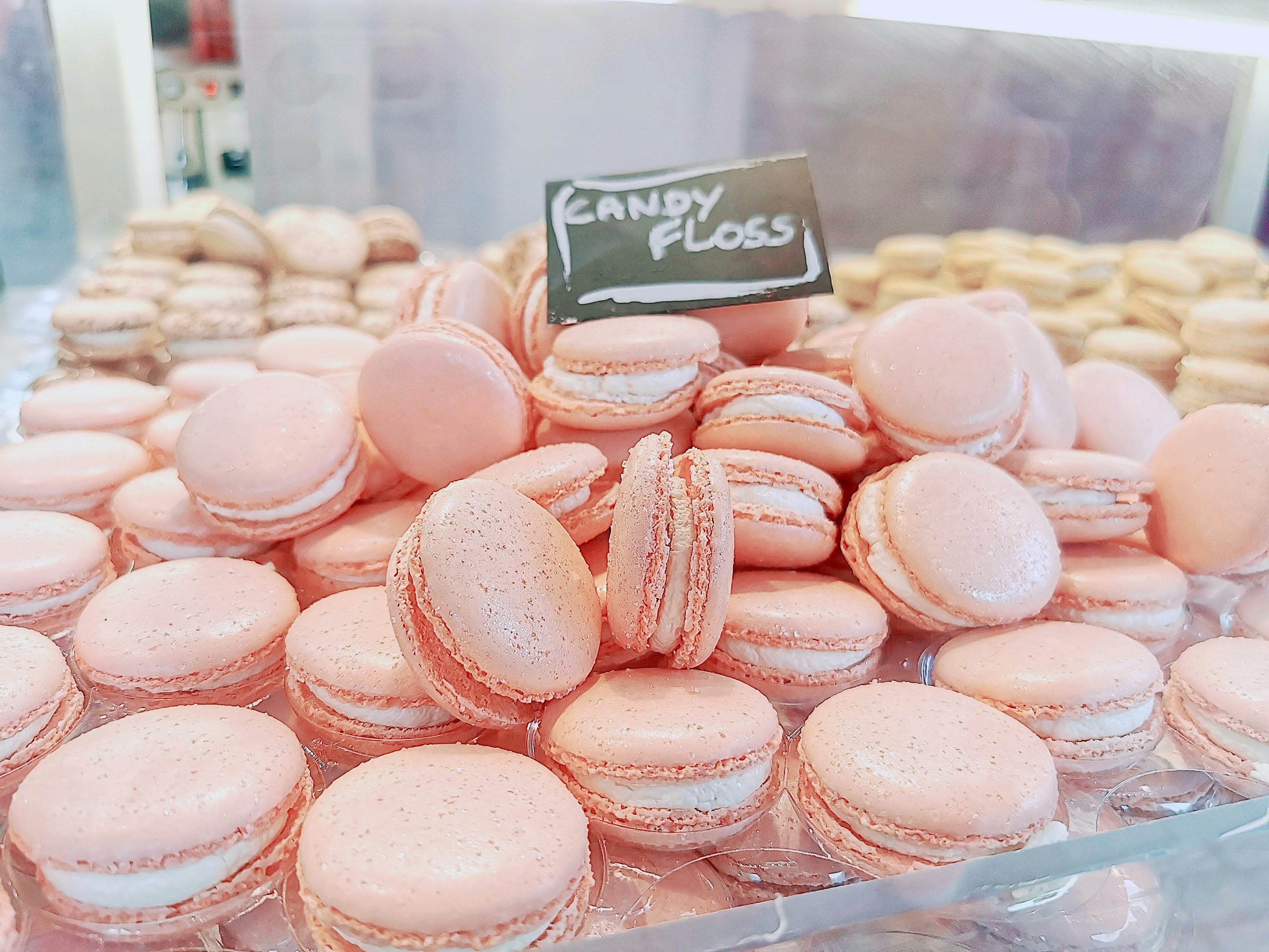 A display of stacked pink macarons in a sweet shop