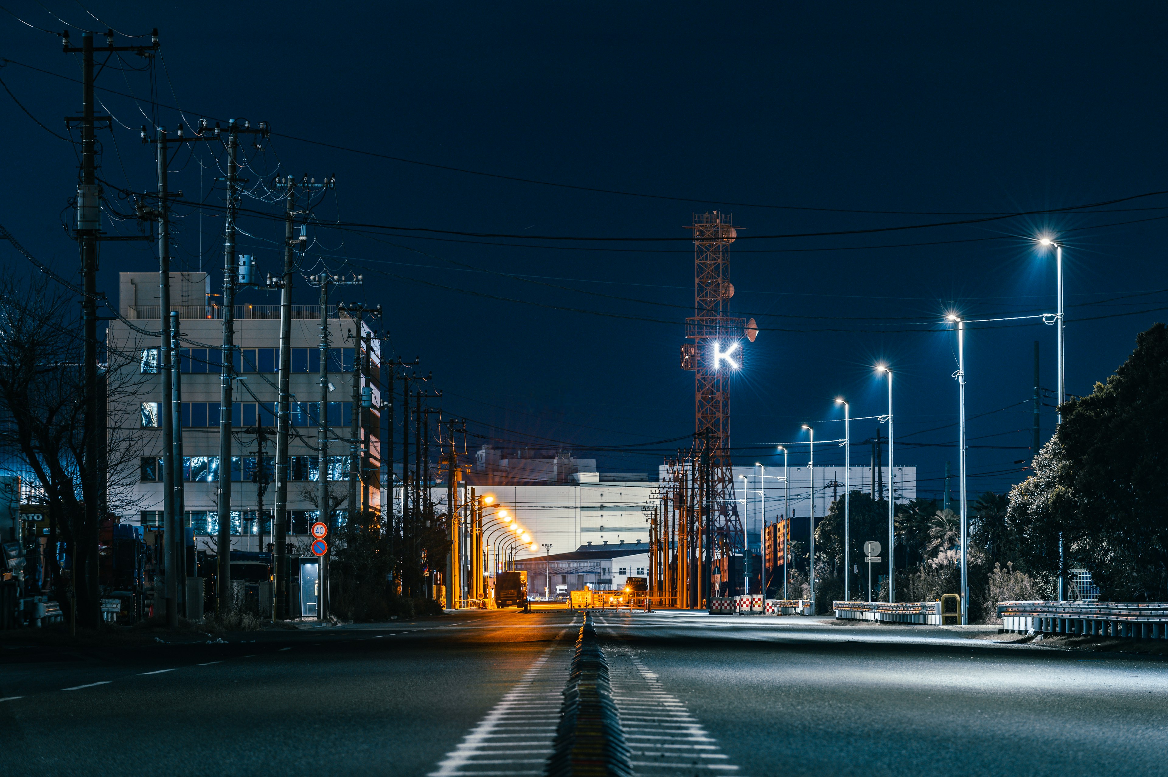 Quiet road at night with city lights and buildings