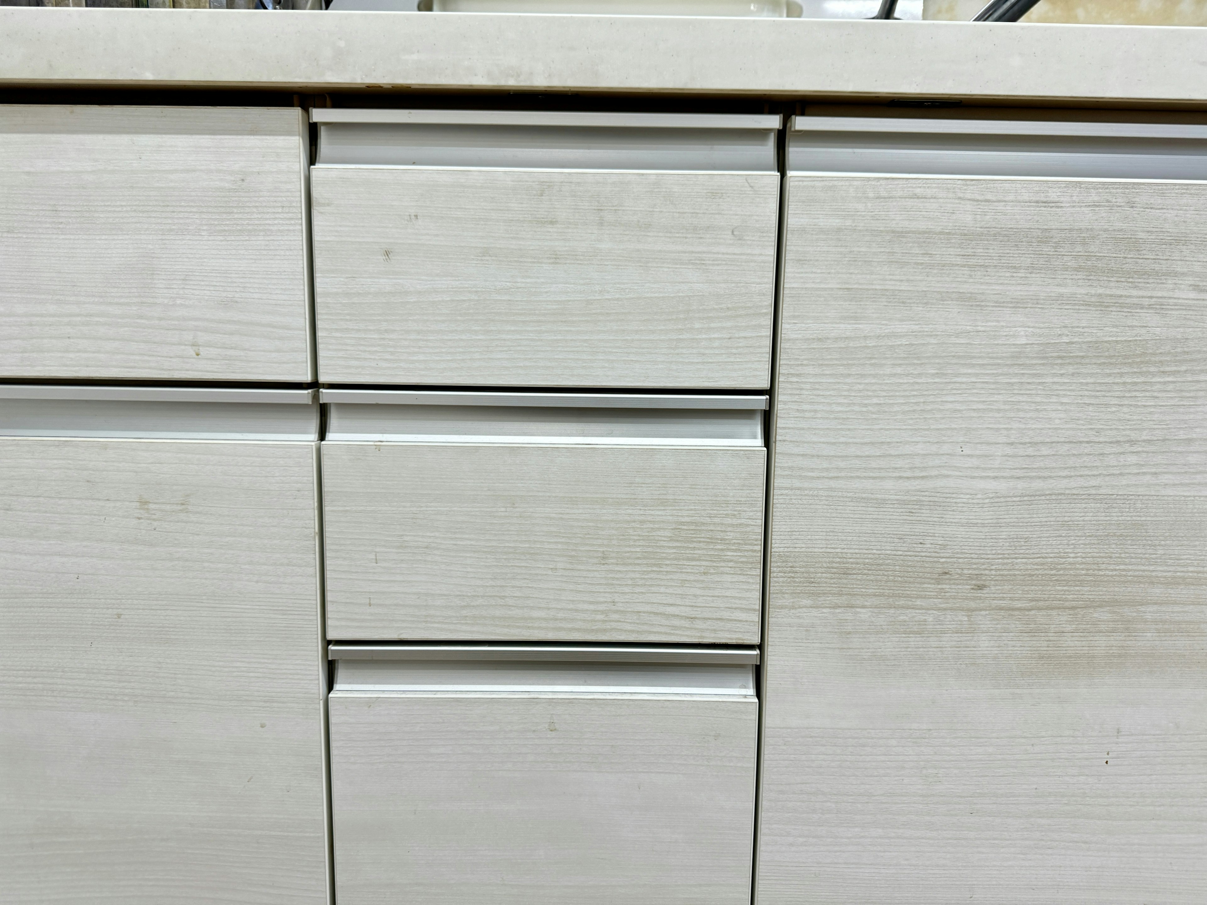 Close-up of white wooden cabinet drawer section