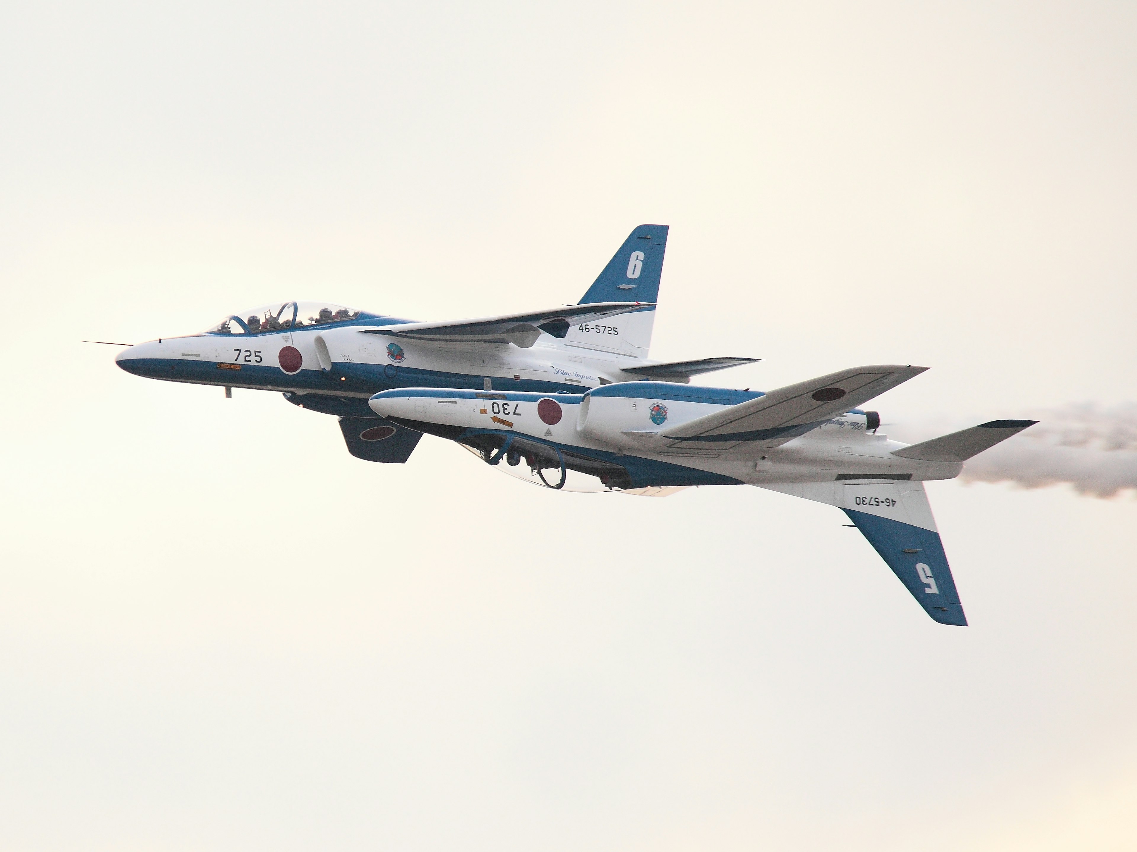 Blue and white aircraft performing a maneuver