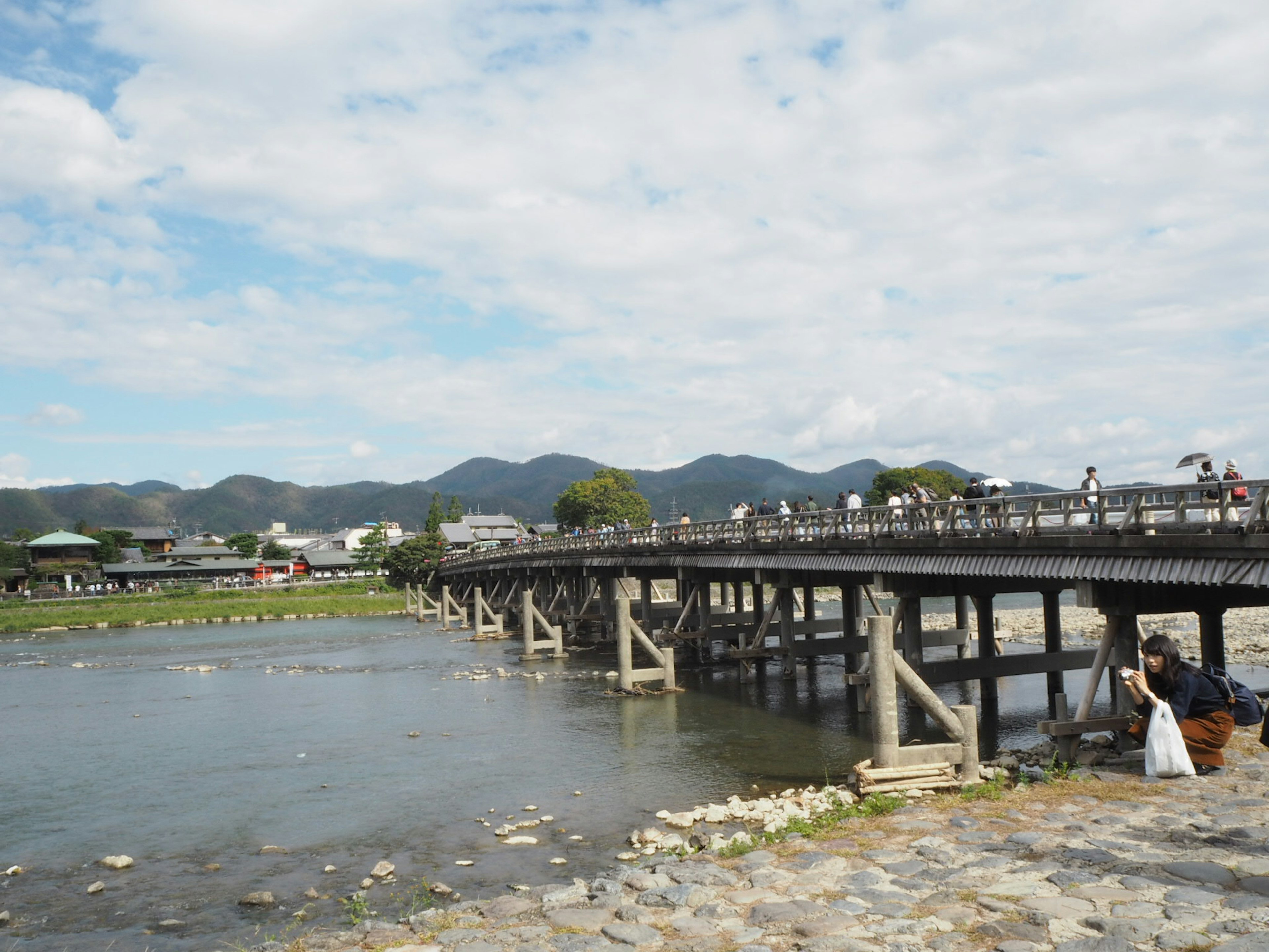 大きな木製の橋と川の風景　青空と山々が背景にある風景