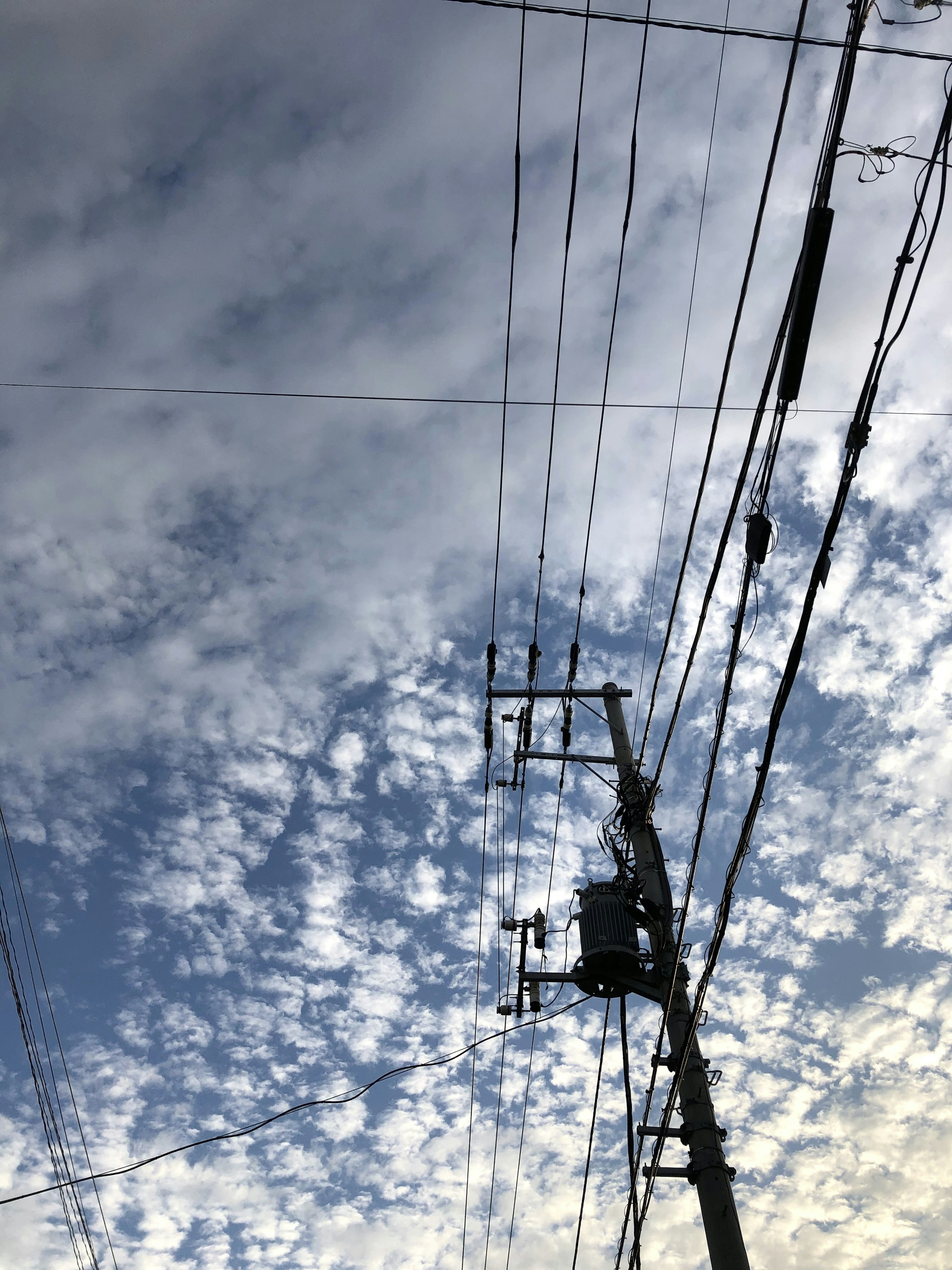 Photo of clouds in a blue sky with a utility pole