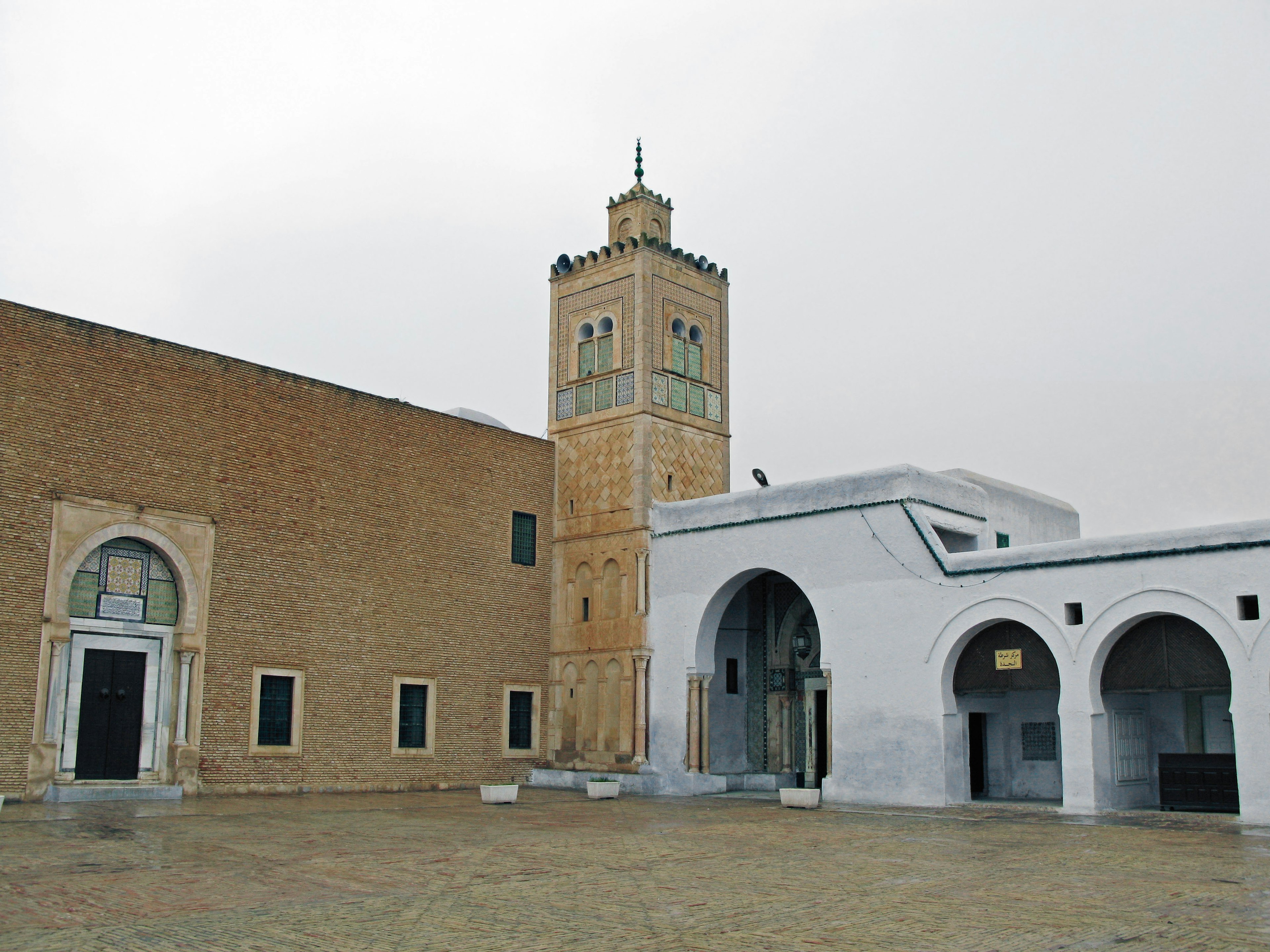 Place avec une tour de mosquée et un complexe architectural traditionnel