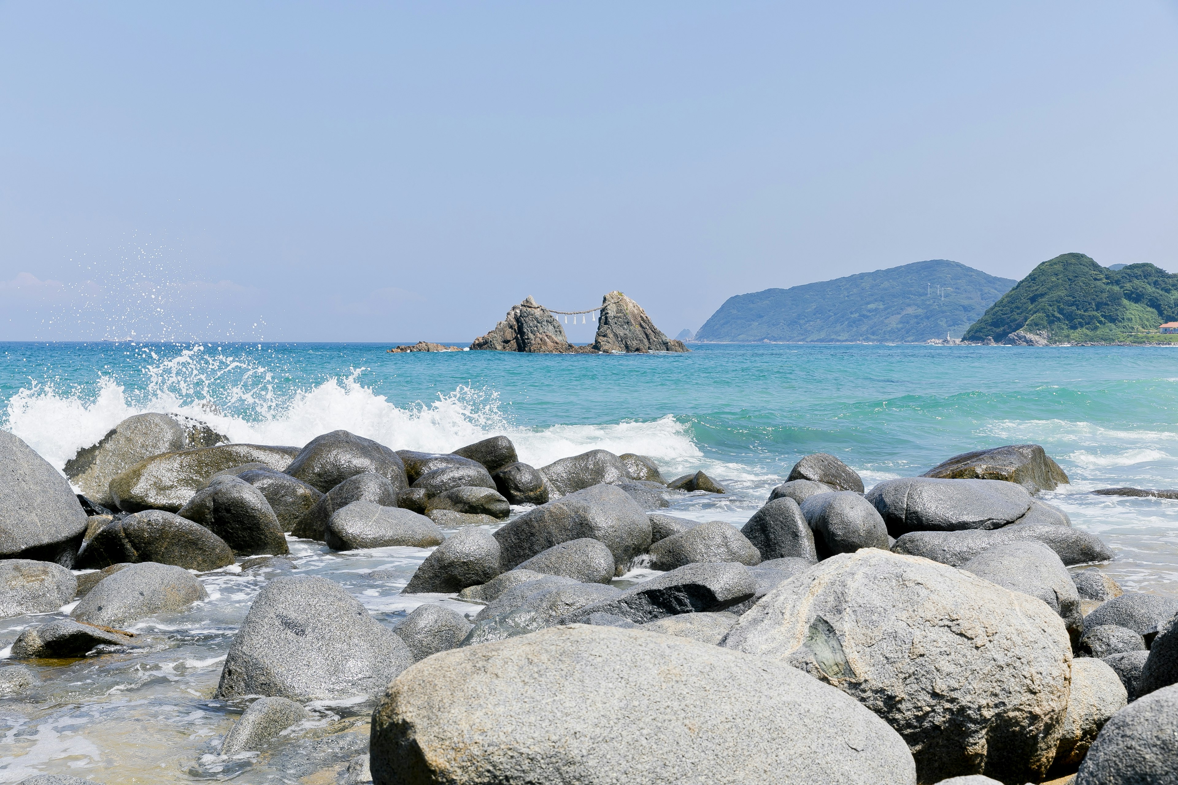 Malersicher Blick auf einen Strand mit blauem Wasser und Felsen