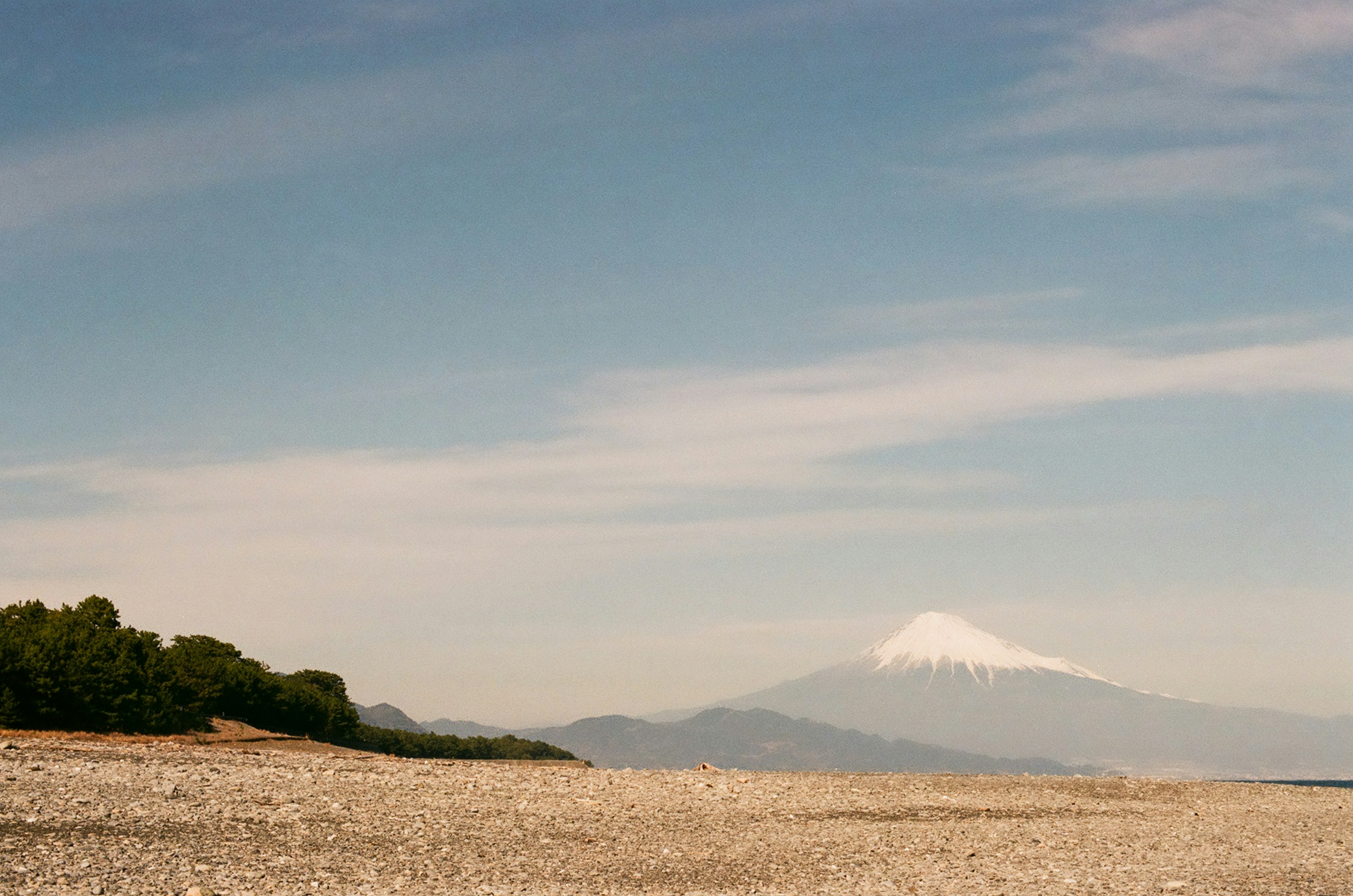 富士山が雪をかぶり空と山々の間に見える風景