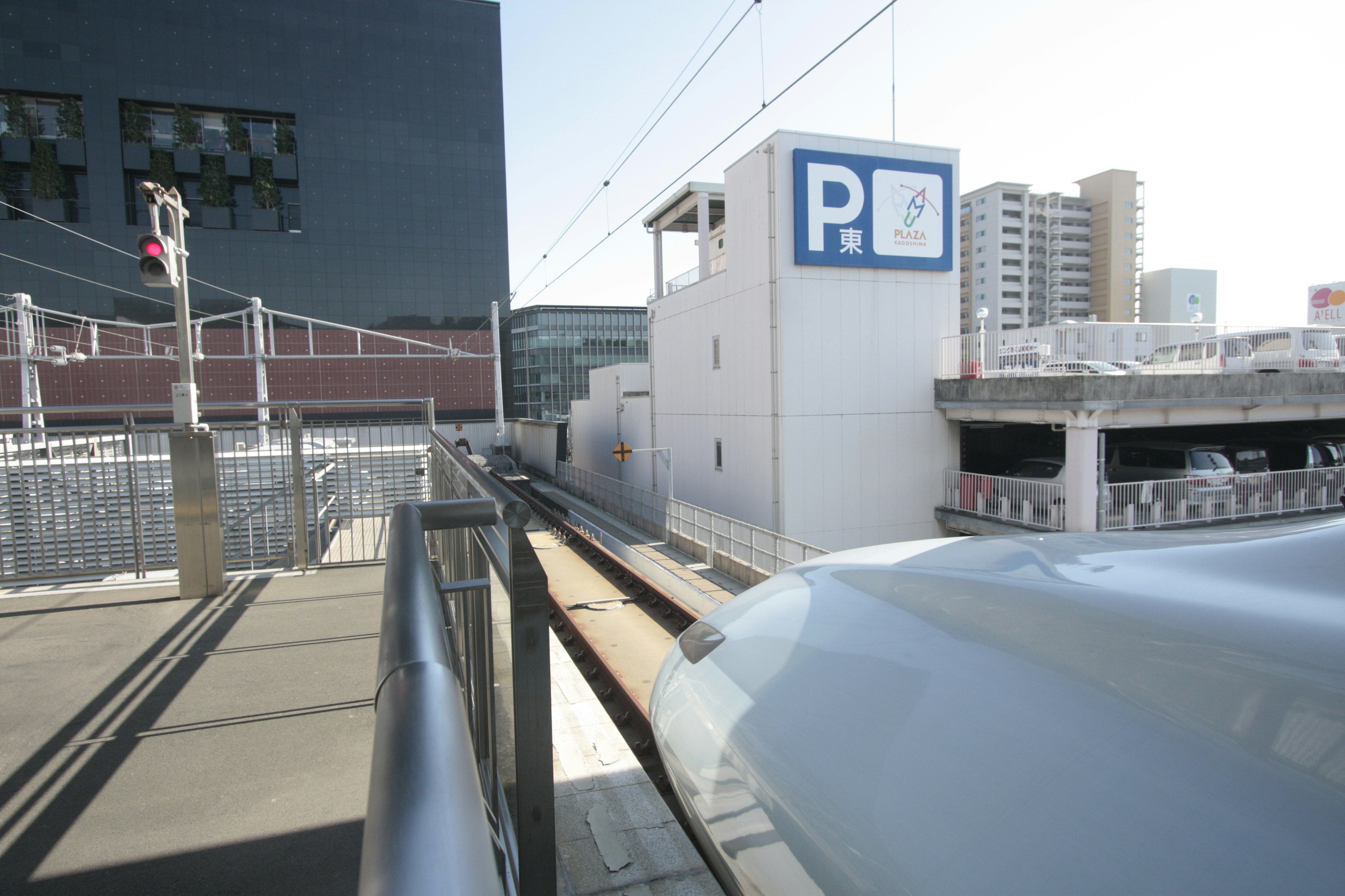 新幹線の線路と駅の駐車場が見える風景