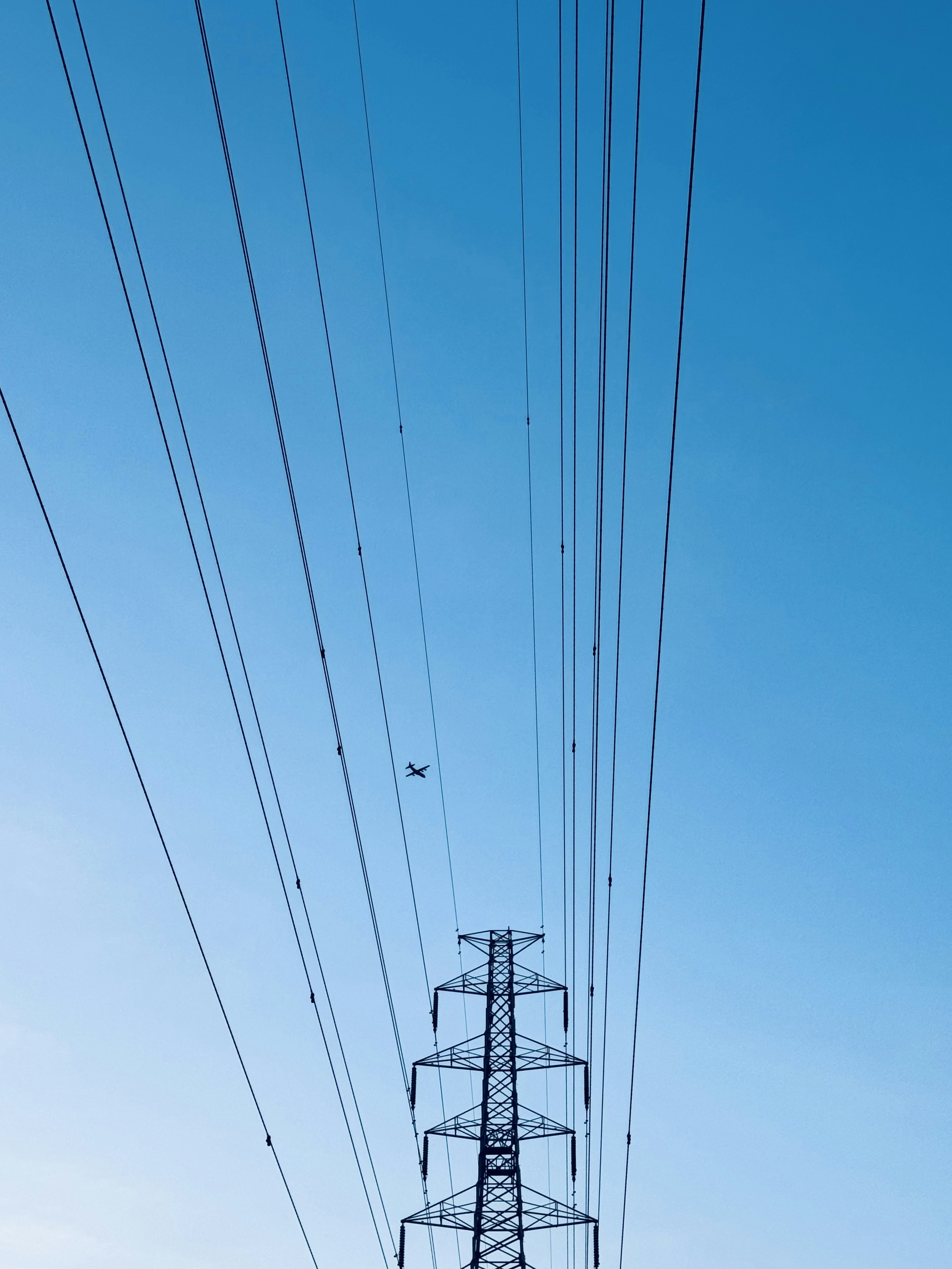 High voltage power lines and tower against a blue sky