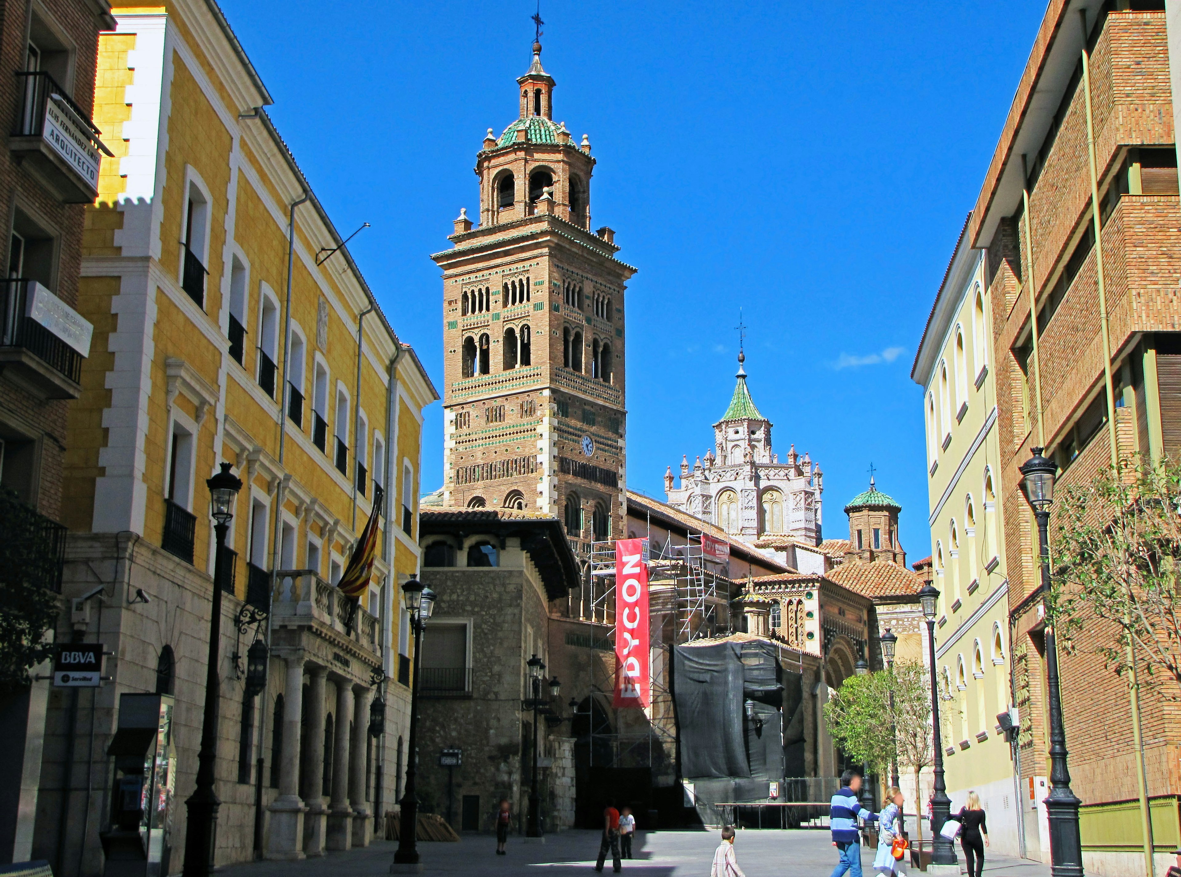 Vista storica di una strada con una torre alta e edifici colorati in Spagna