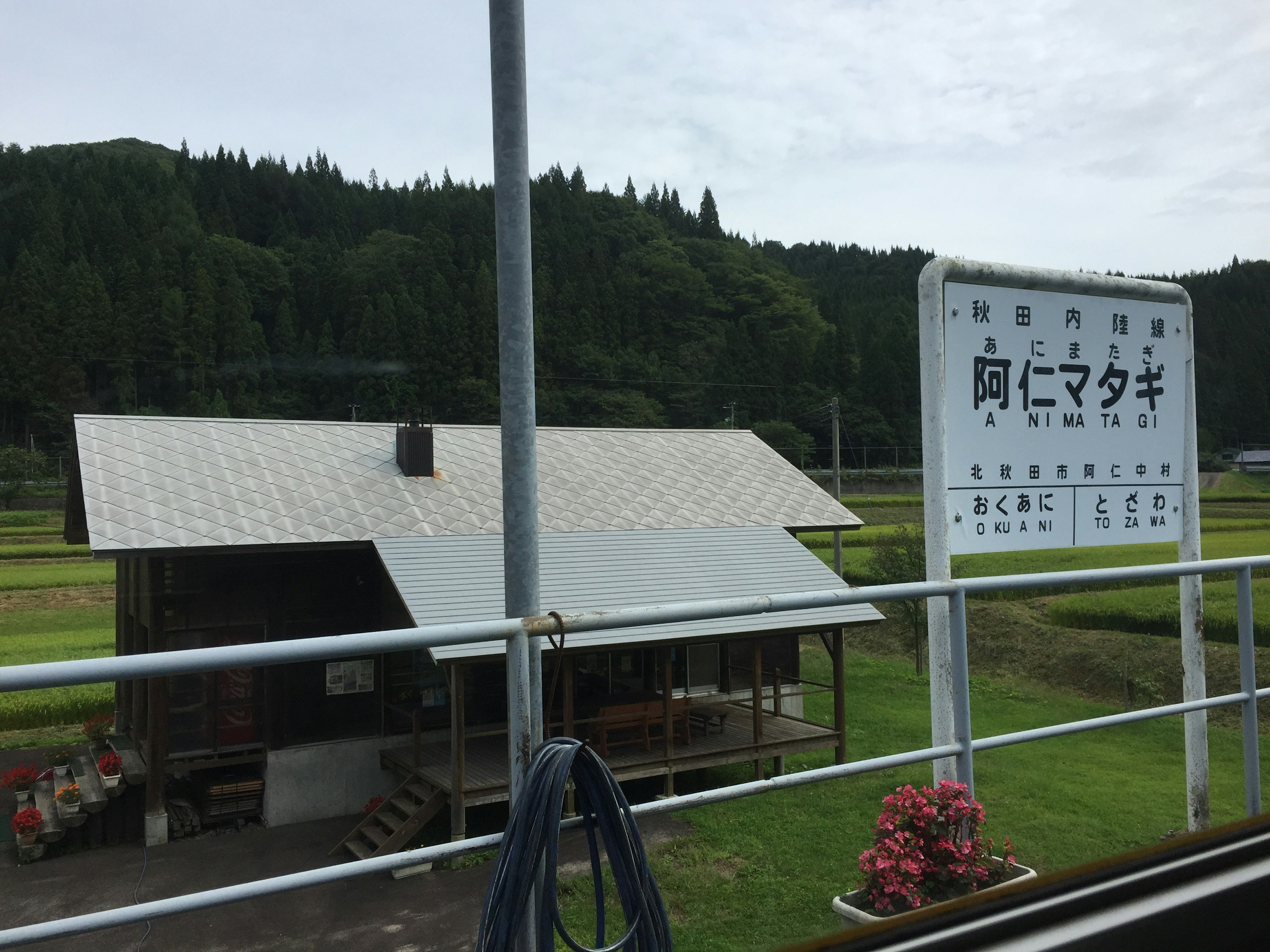 Sign of Ani Matagi Station with surrounding rural landscape