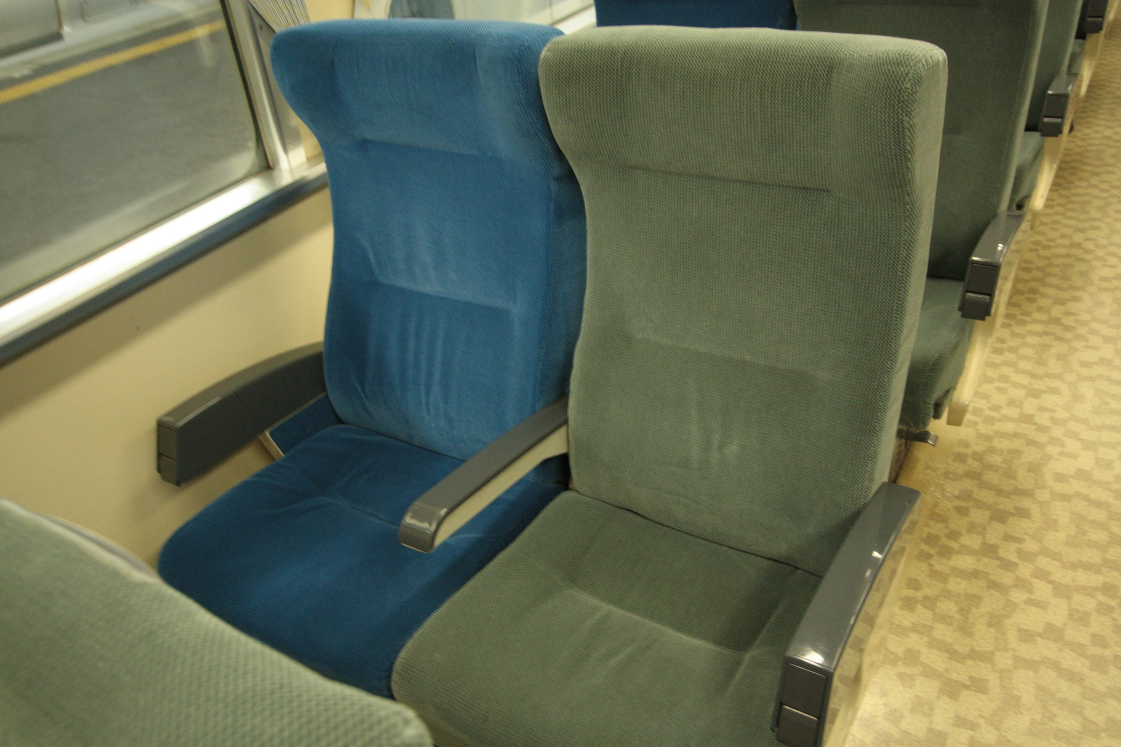 Interior of a train featuring blue and green upholstered seats