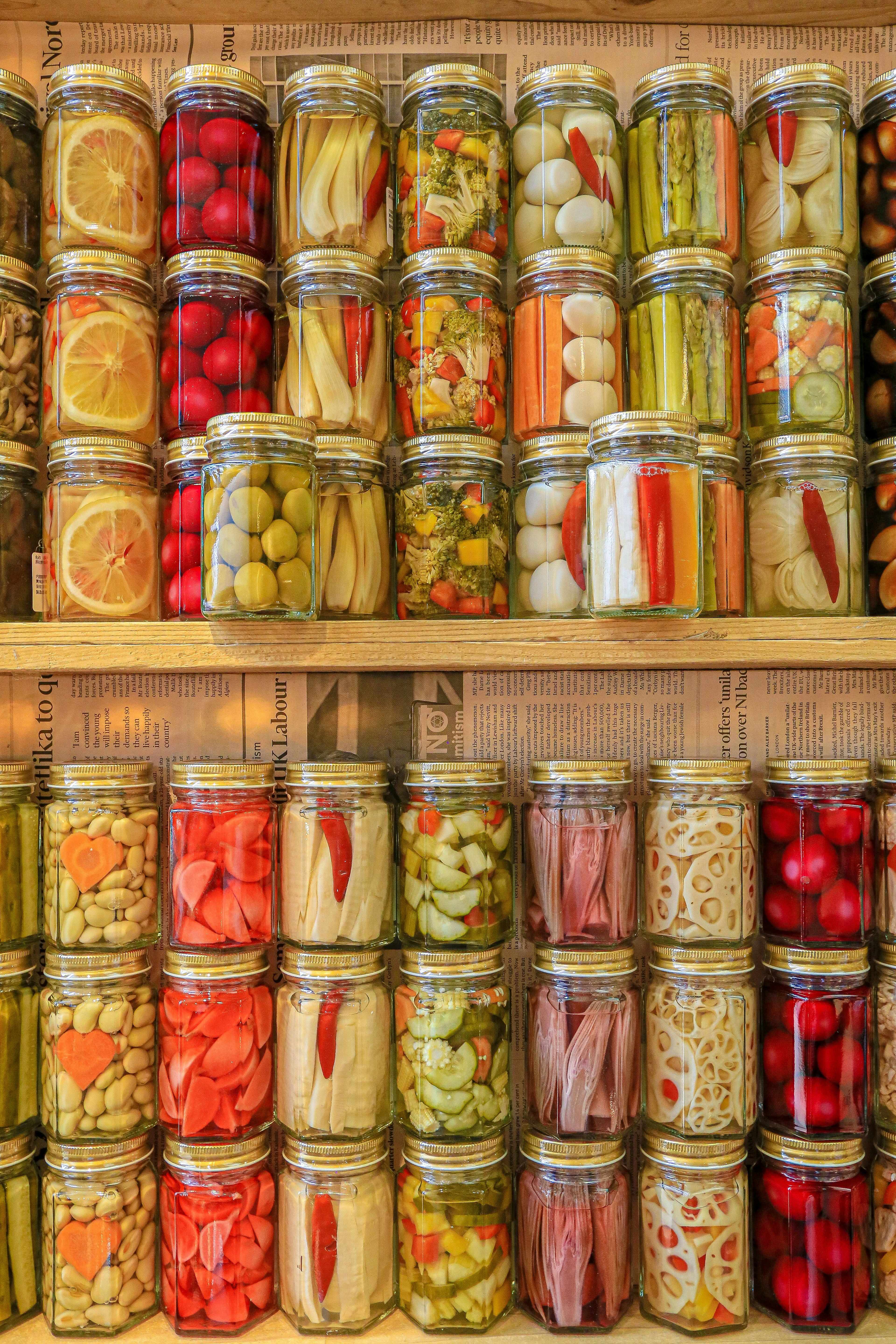 A shelf filled with colorful jars of preserved vegetables and fruits arranged neatly