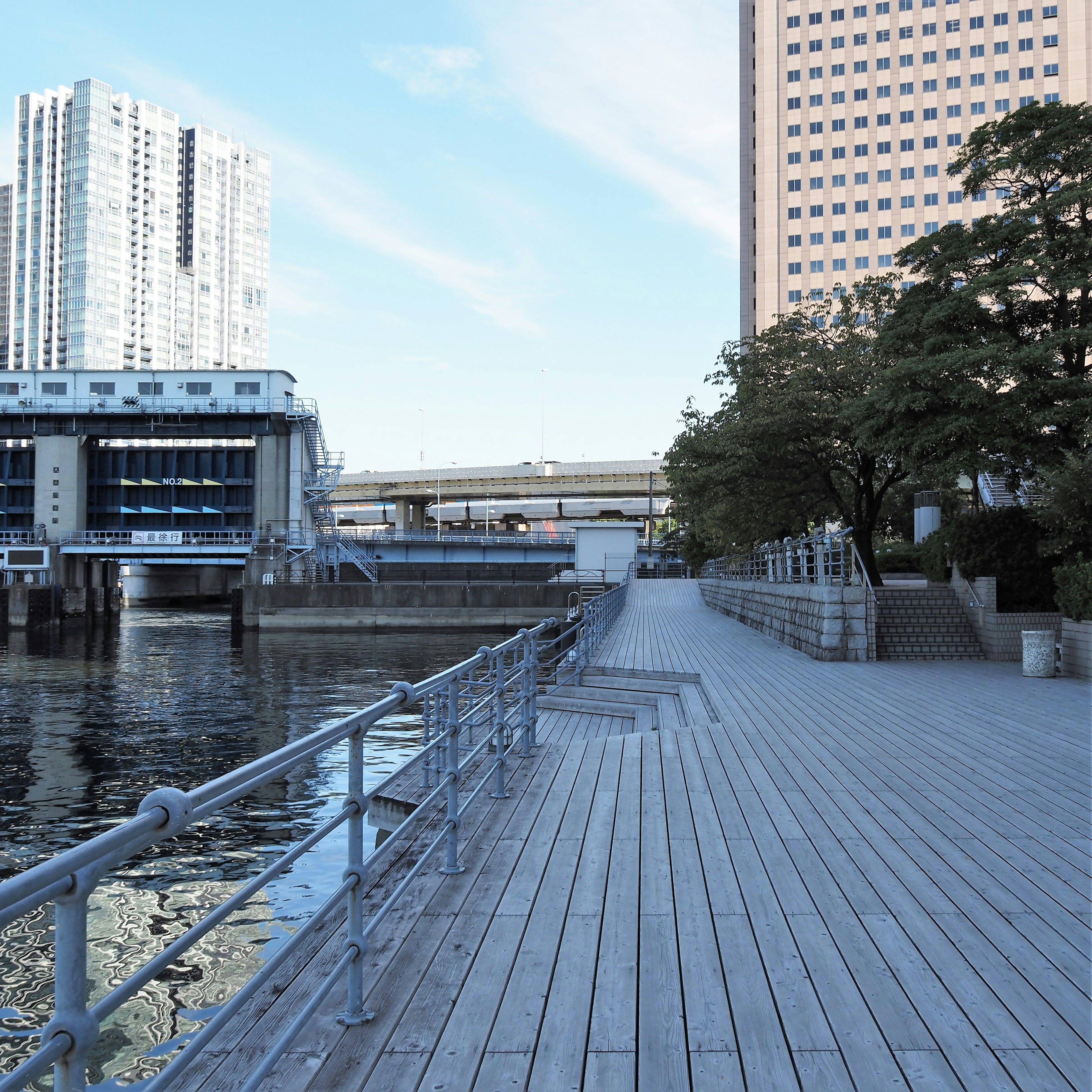 川沿いの木製の歩道と高層ビルの景色