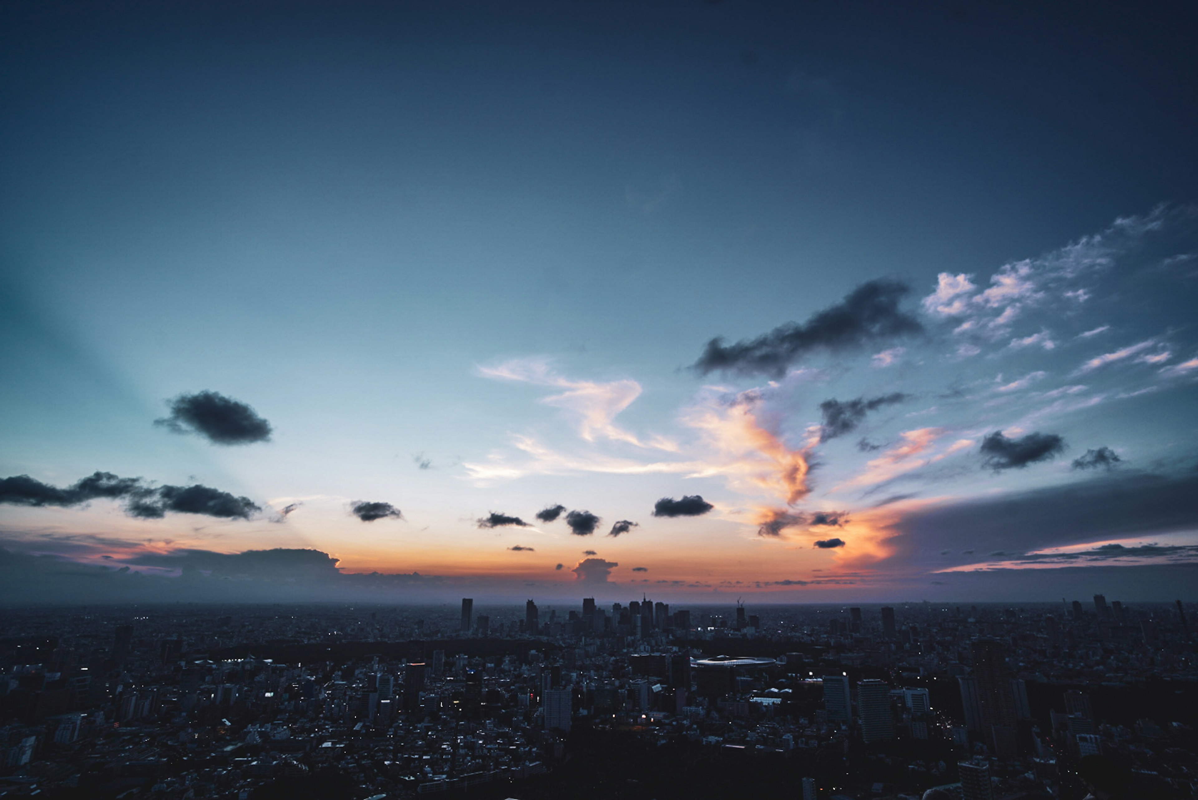 Hermoso paisaje de atardecer con cielo azul silueta de la ciudad y detalles de las nubes