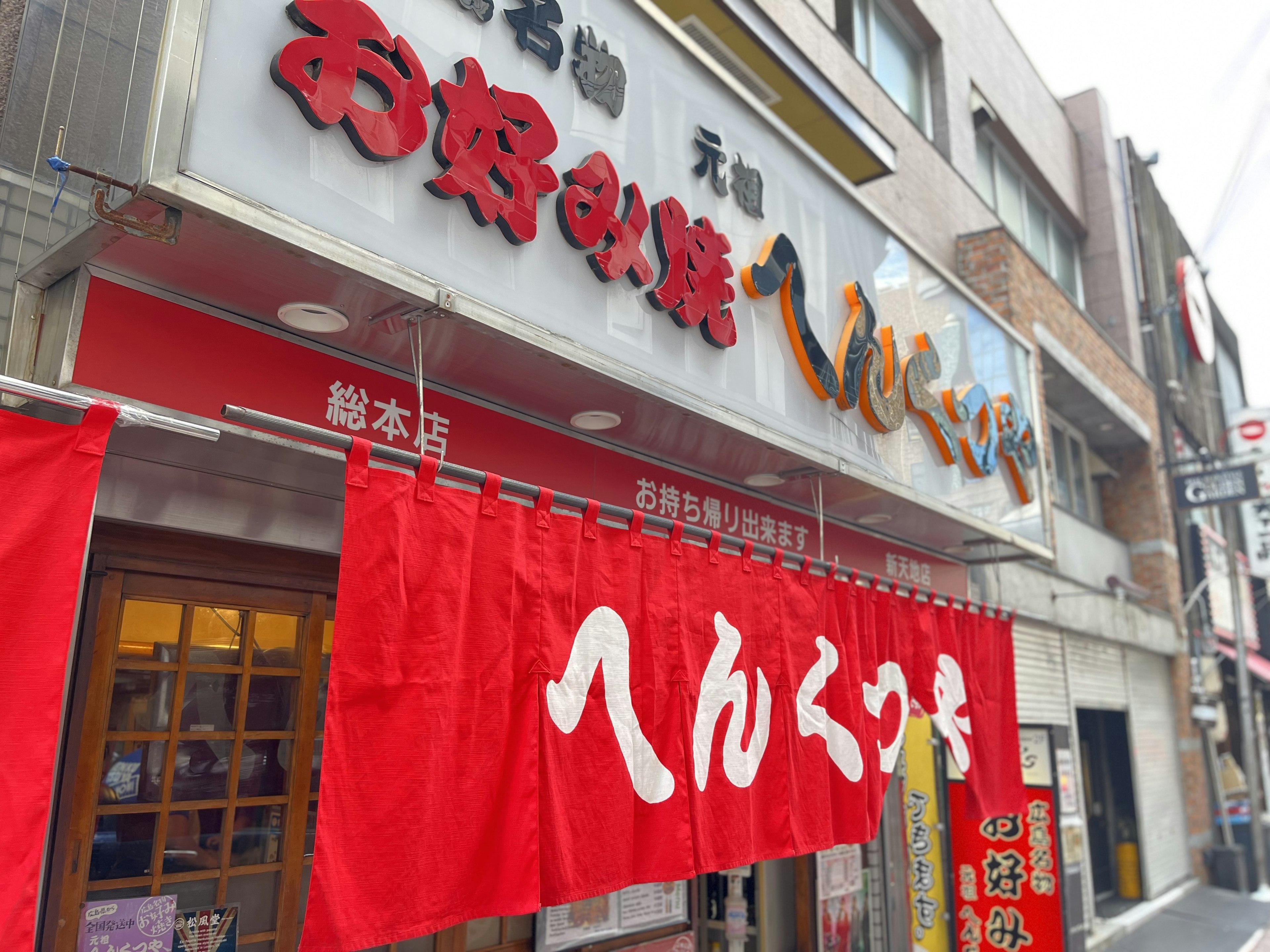 Außenansicht eines japanischen Restaurants mit einem auffälligen roten Banner und Namen