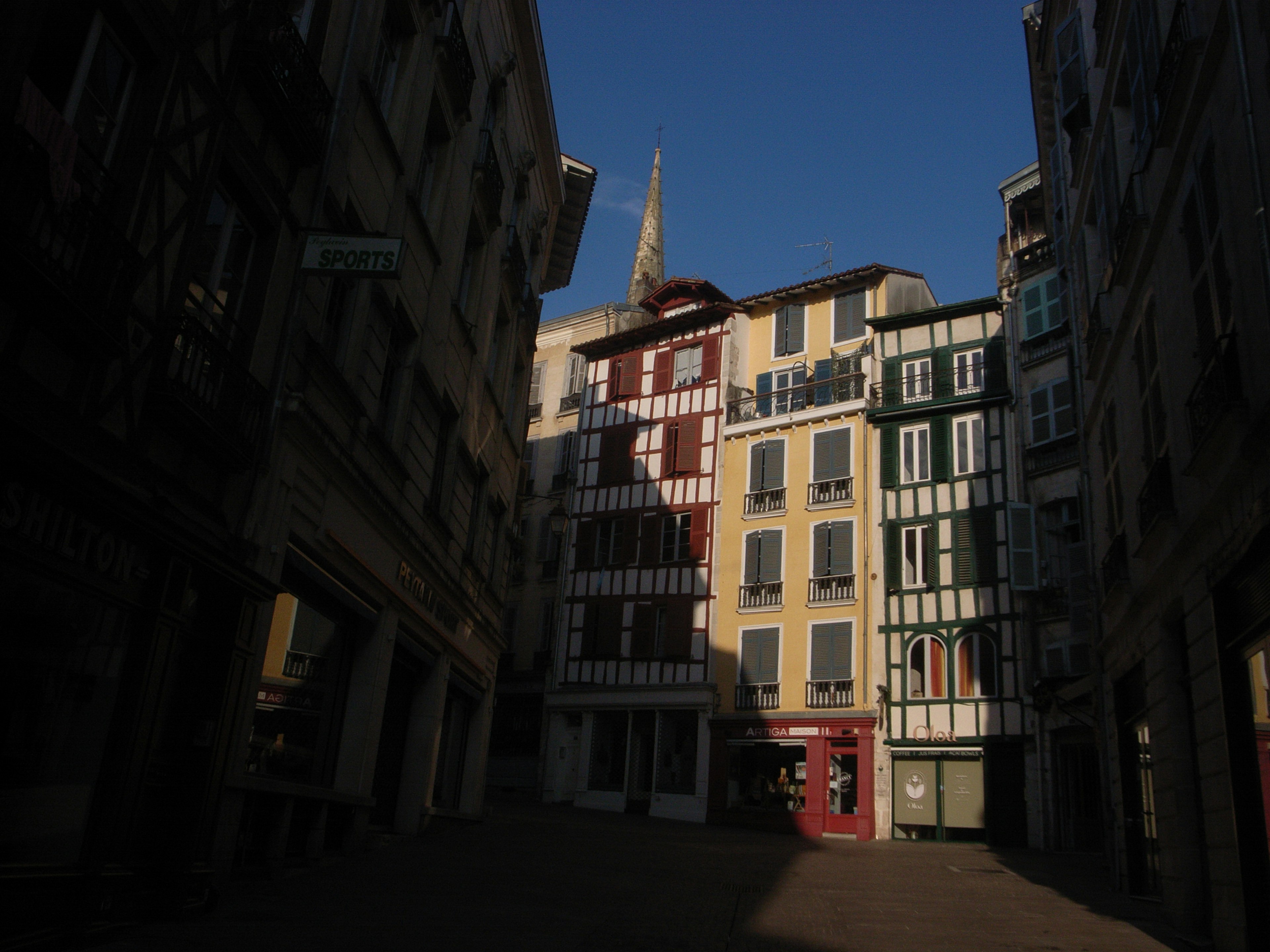 Calle estrecha con casas coloridas bajo un cielo azul