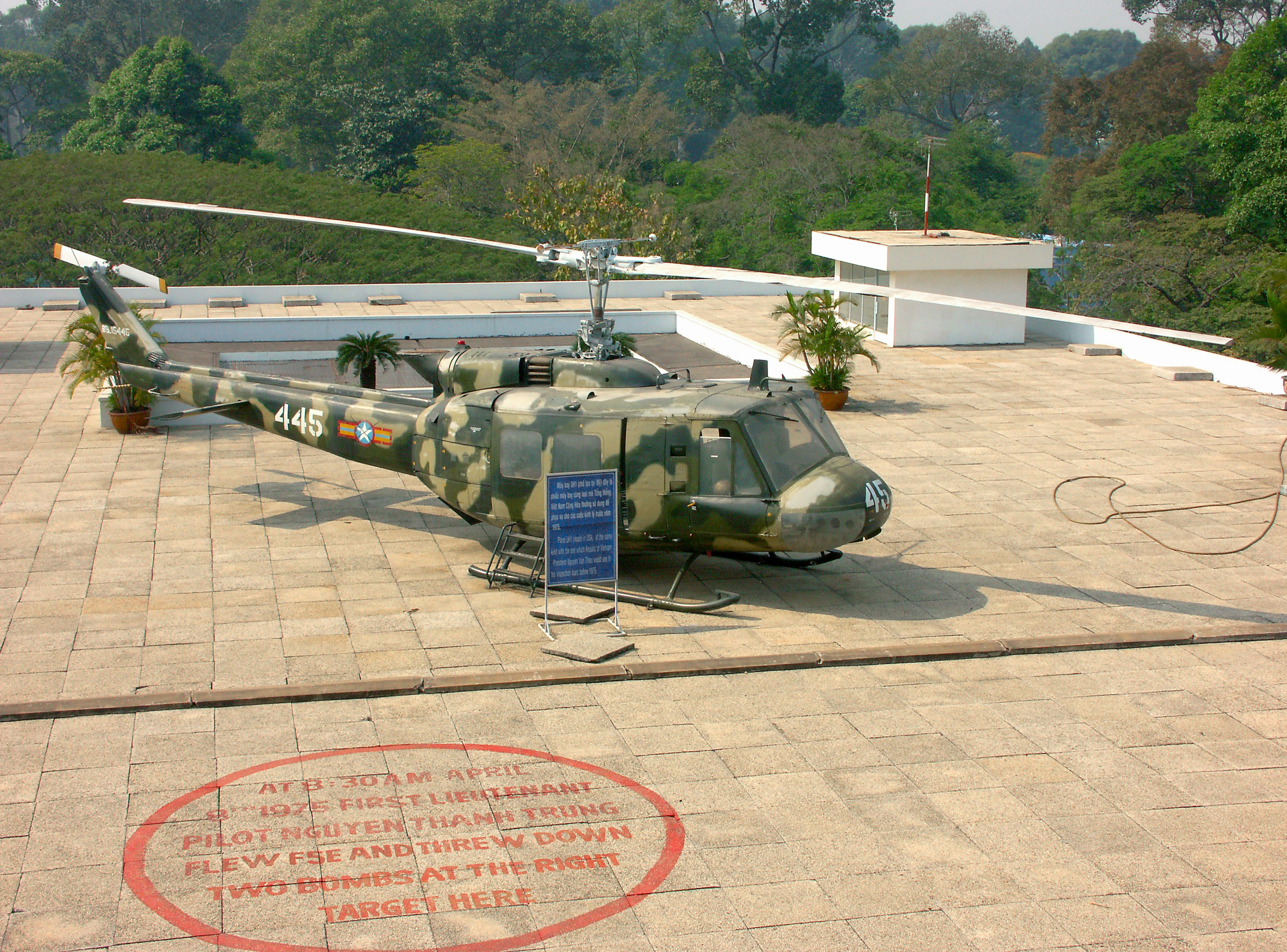 Helikopter kamuflase di atap dikelilingi oleh pepohonan