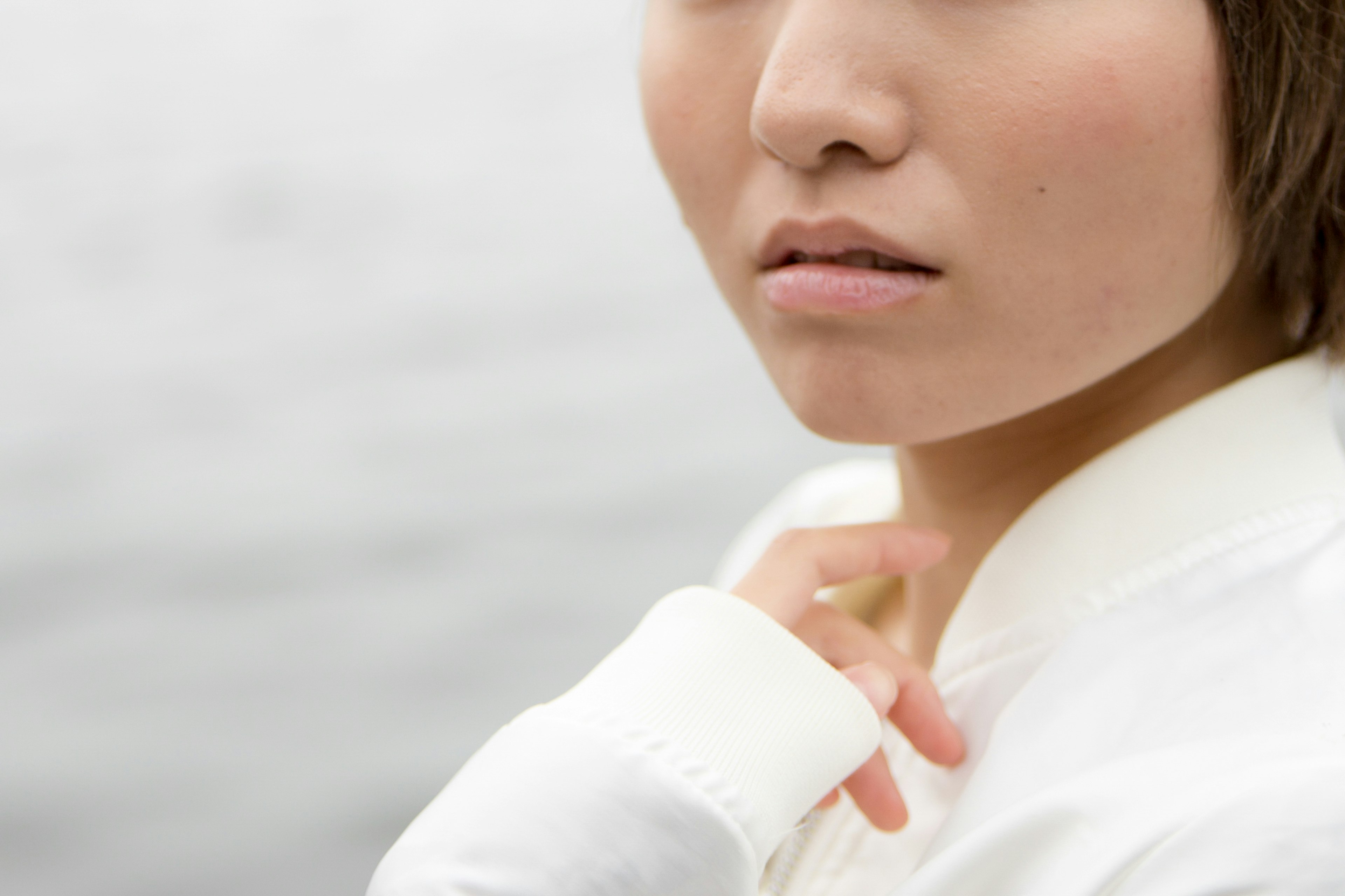 Portrait of a young woman by the water wearing a white outfit with short hair