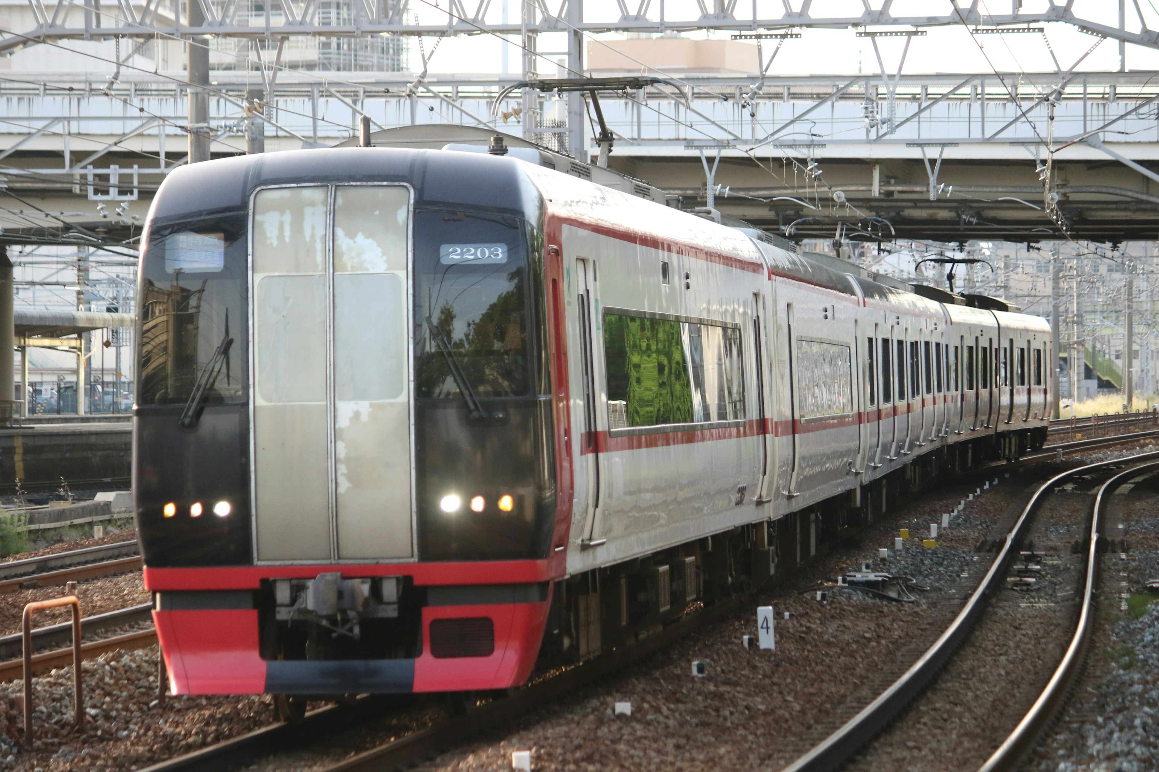 Sebuah kereta merah dan putih berhenti di rel