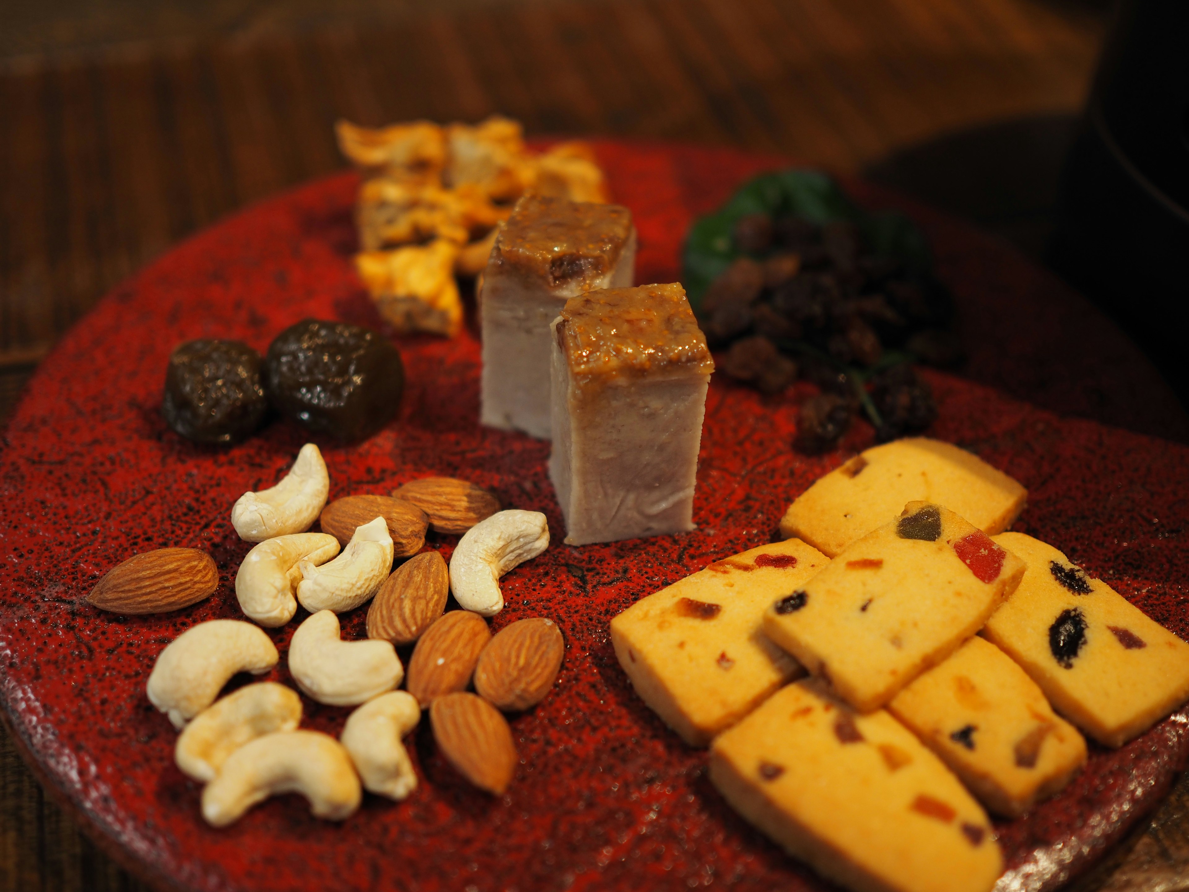 An assortment of sweets and nuts on a red plate