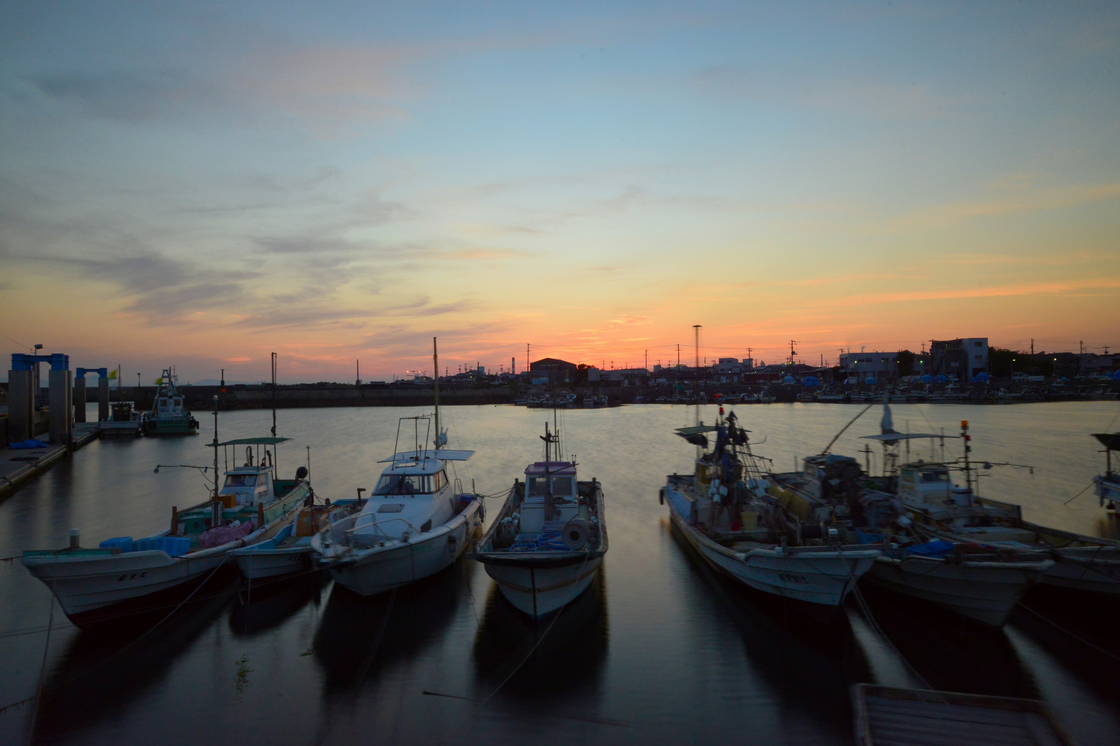 Pescherecci ormeggiati in un porto al tramonto