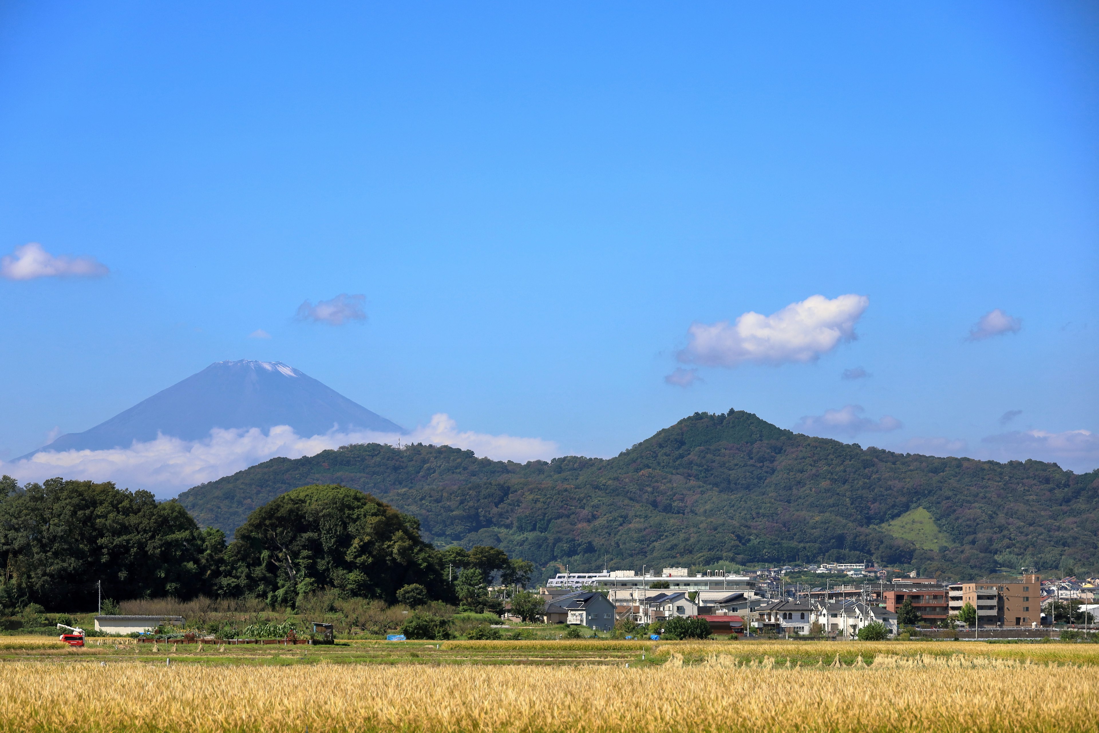 Scenic view of fields and mountains under a clear blue sky with Mount Fuji in the distance