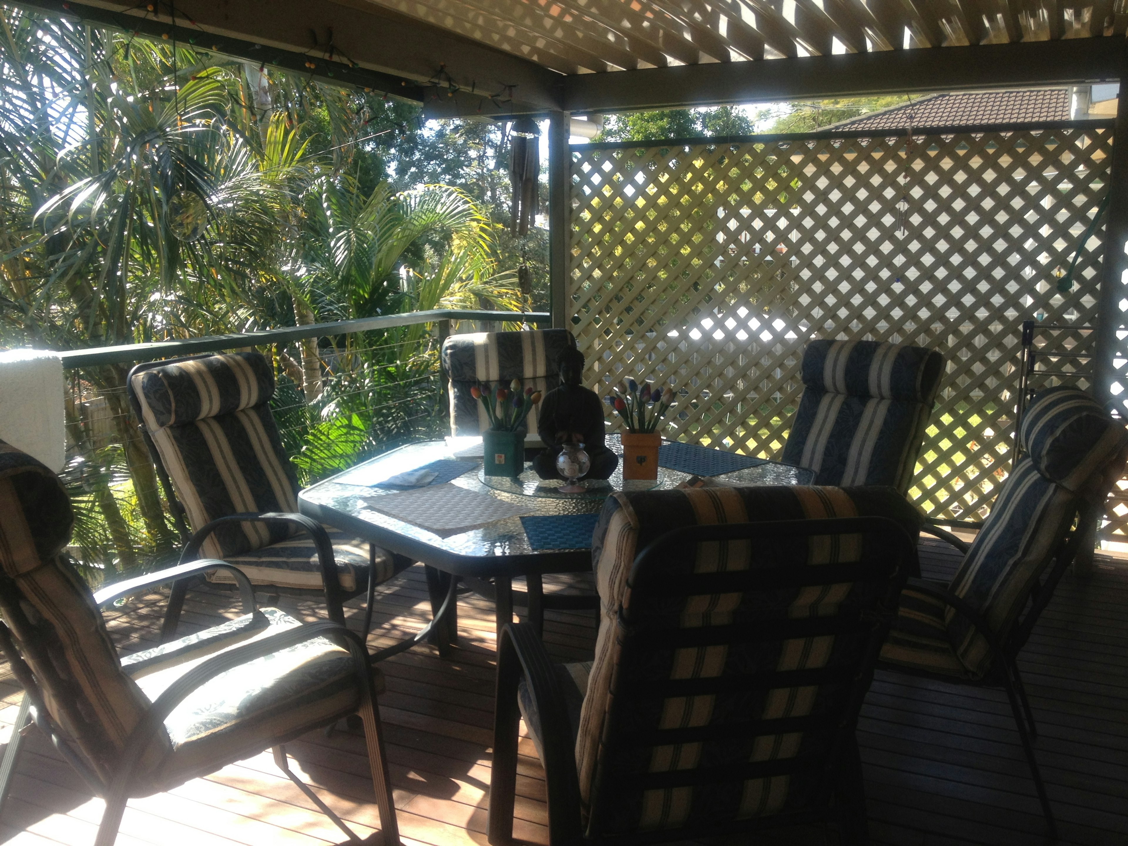 Área de comedor al aire libre con sillas a rayas y una mesa