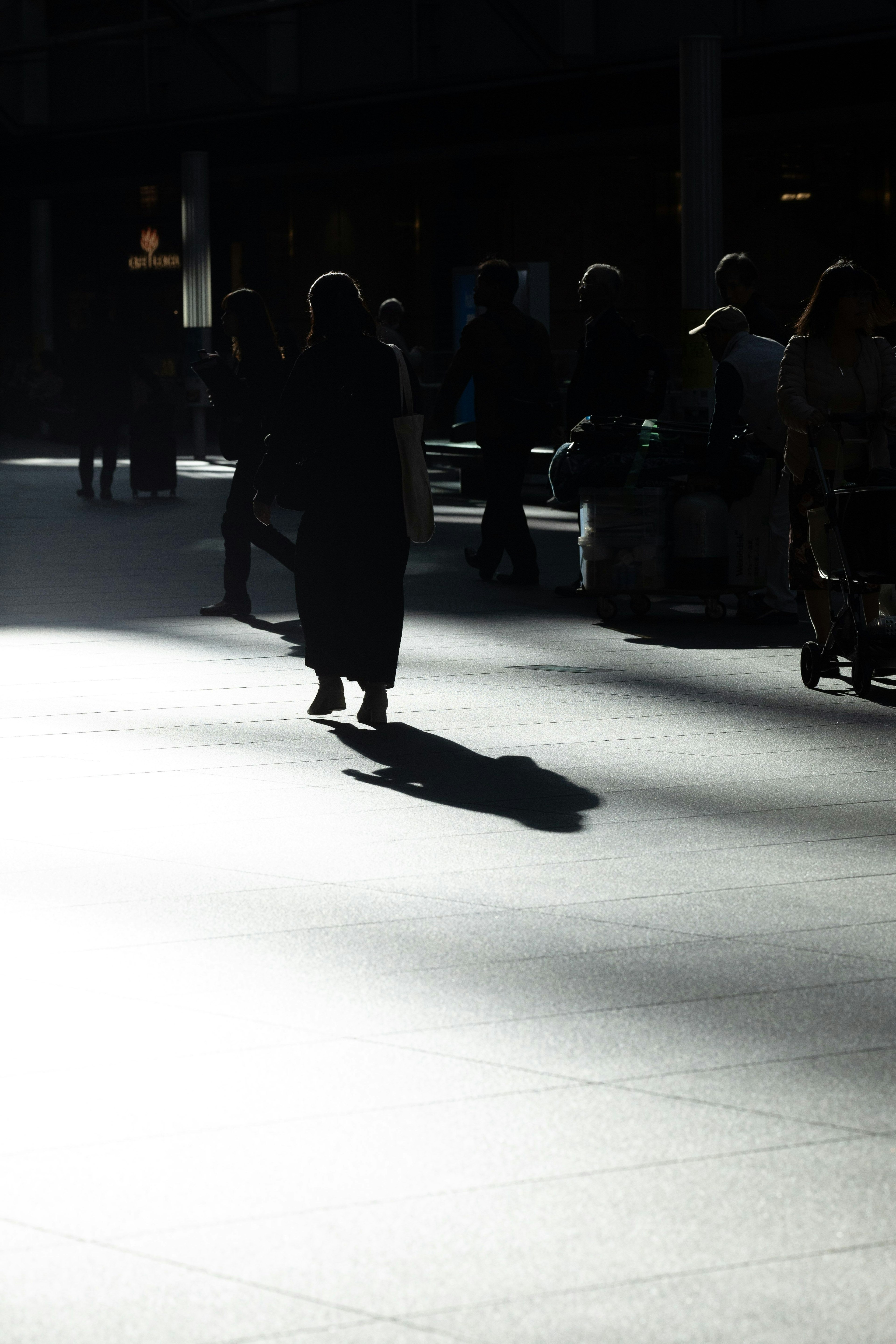 Silhouetten von Menschen, die im Schatten gehen Heller Boden im Kontrast zu einem dunklen Hintergrund