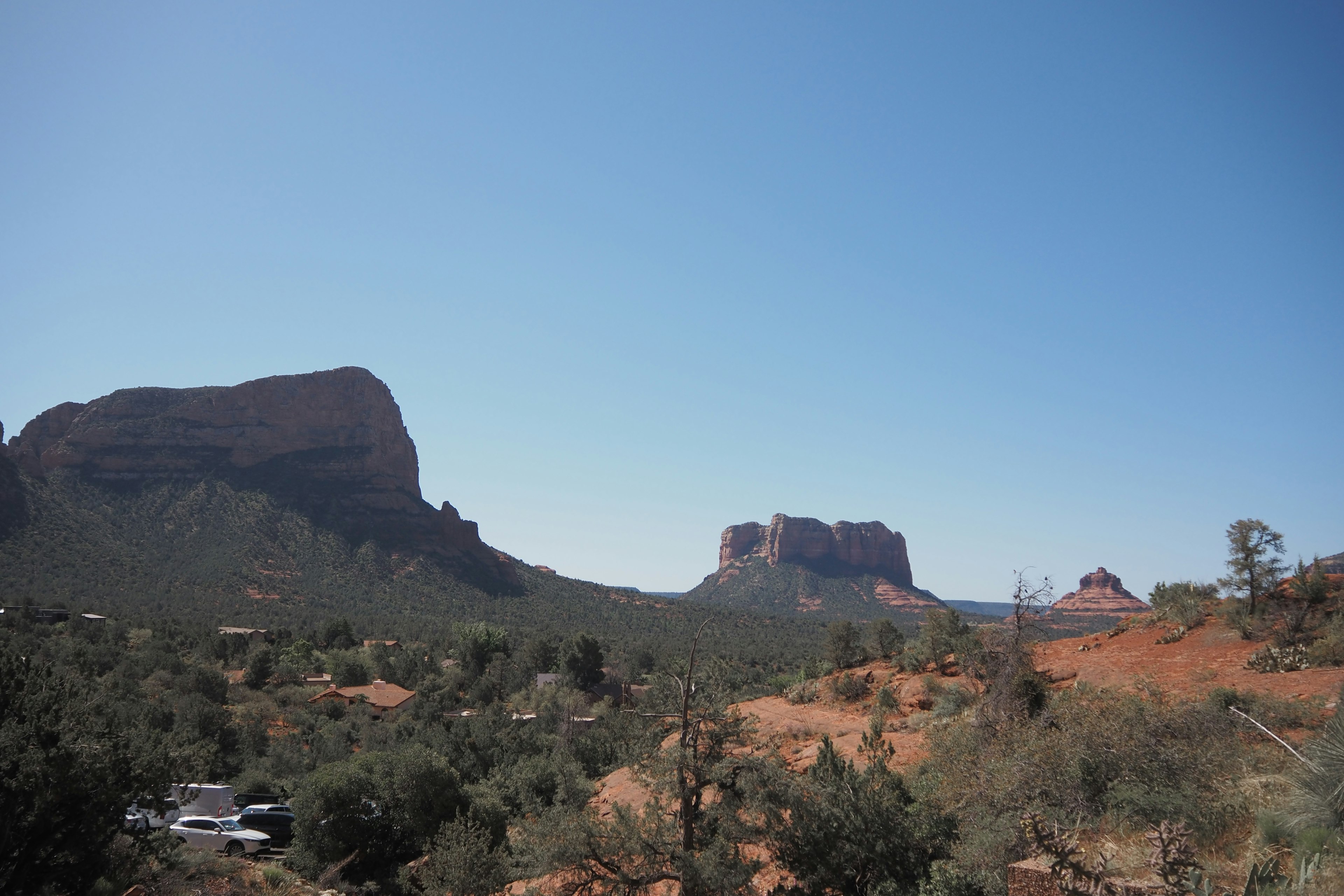 Landscape featuring red rock formations and a clear blue sky