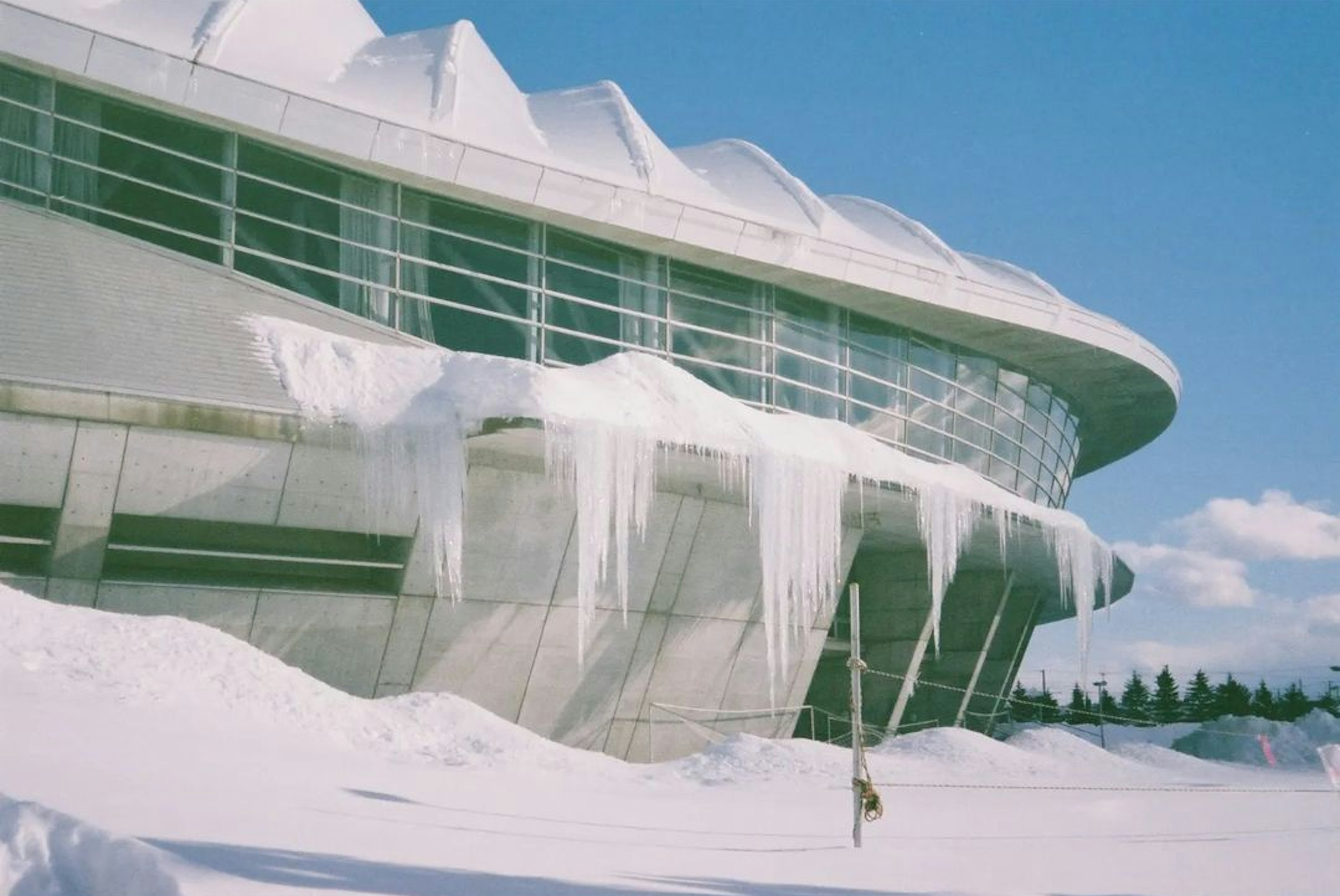 雪に覆われた現代的な建物と氷柱