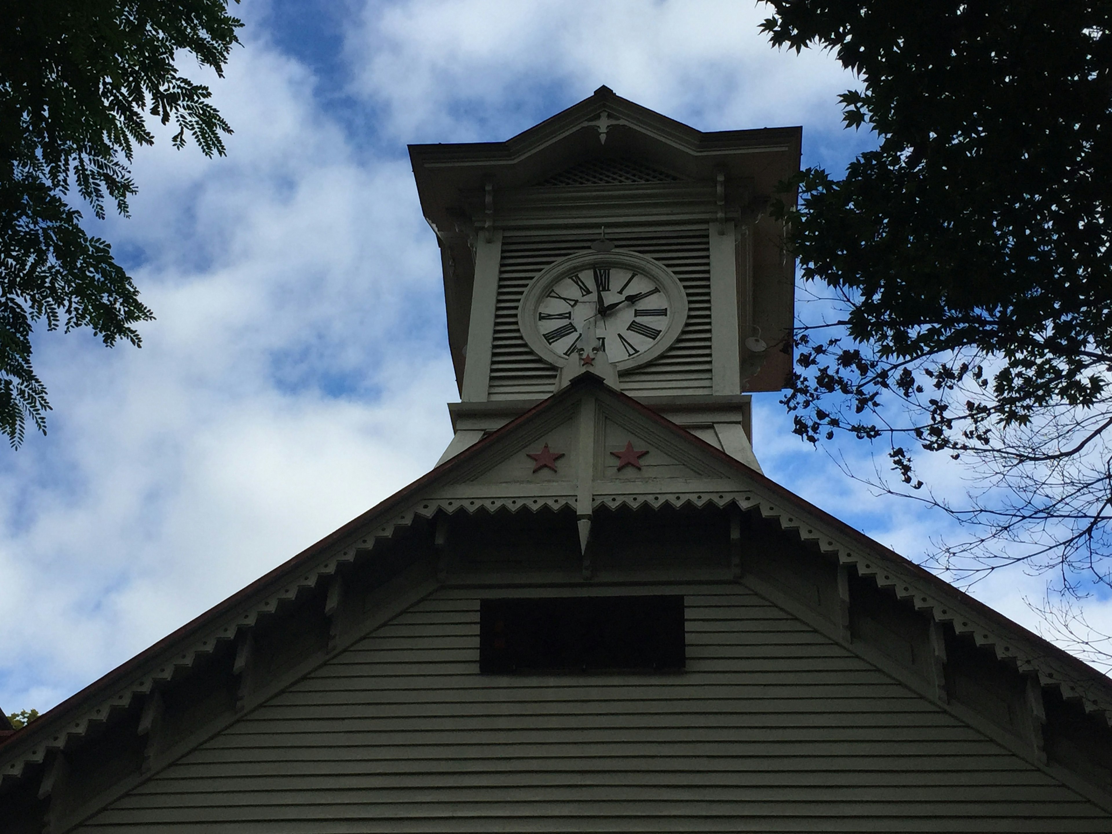 View from below of a building with a clock tower against a cloudy sky