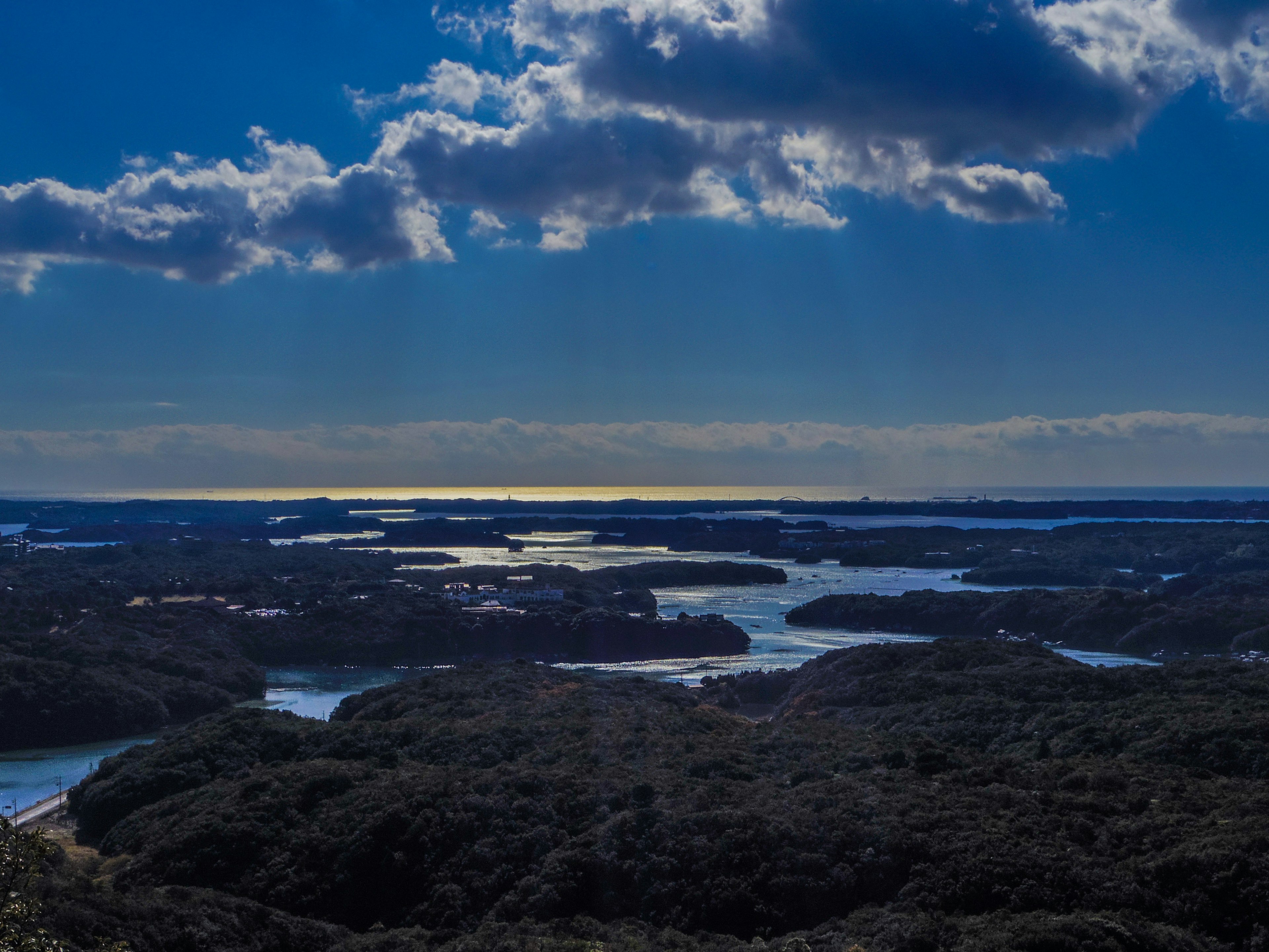 Vista panoramica di cielo blu con nuvole sopra acque tranquille circondate da isole lussureggianti