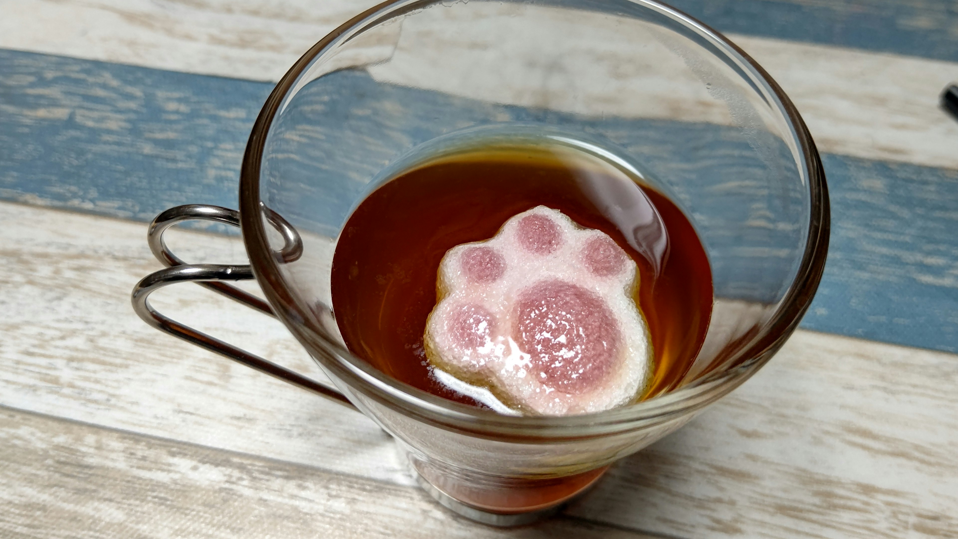 A cute paw-shaped marshmallow floating in tea