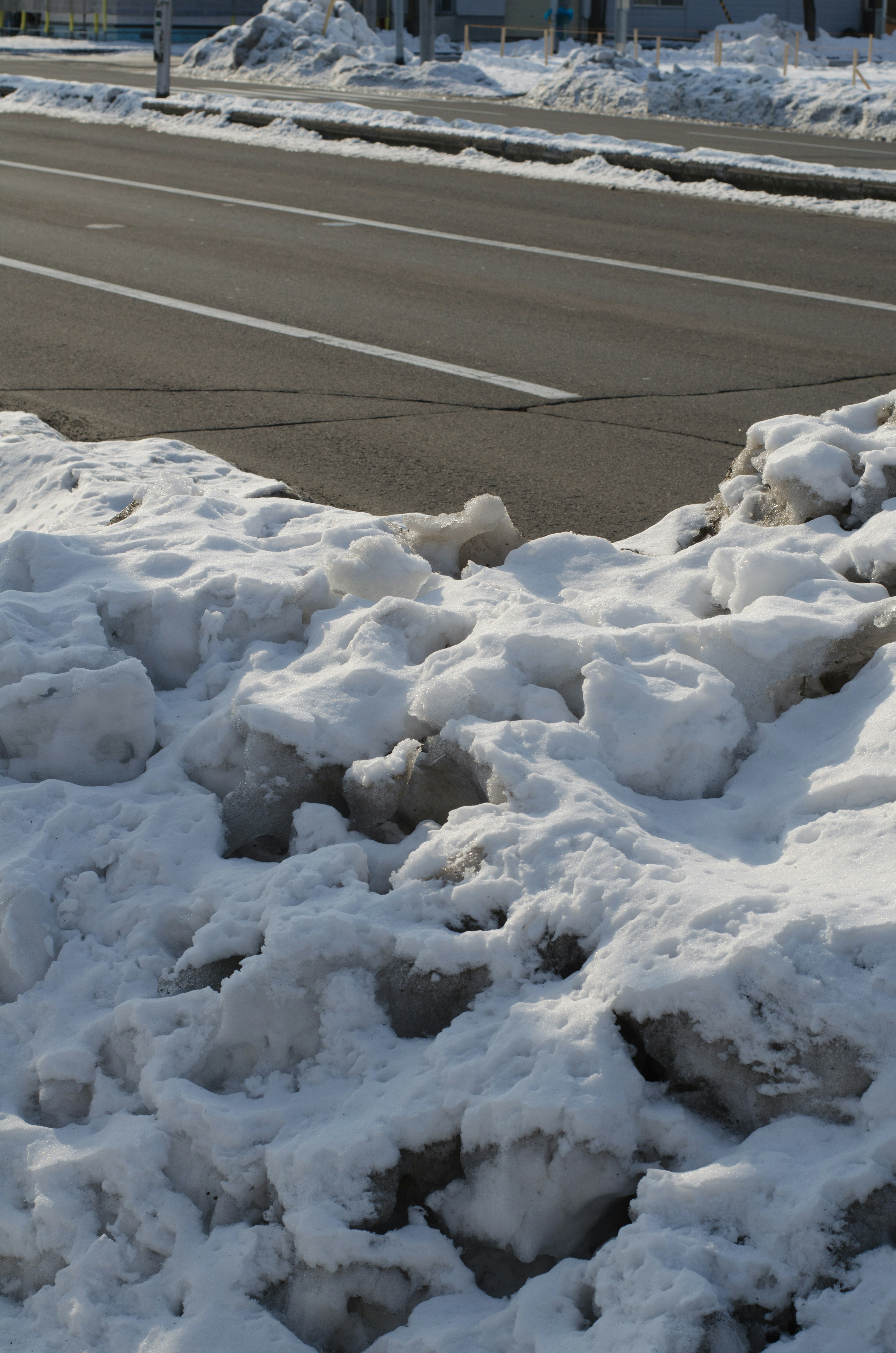 Piled snow beside an asphalt road