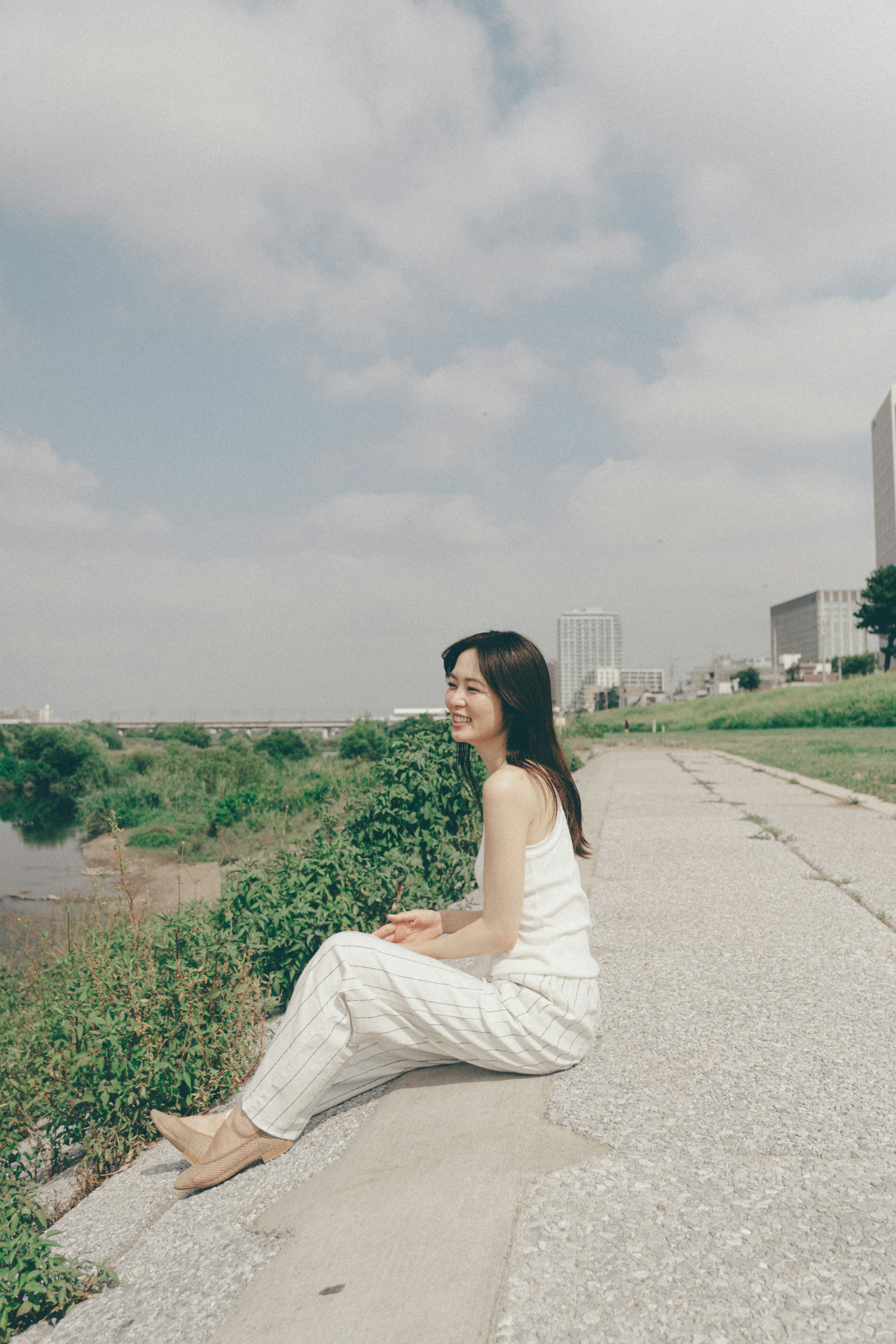 Woman in white dress sitting by the river