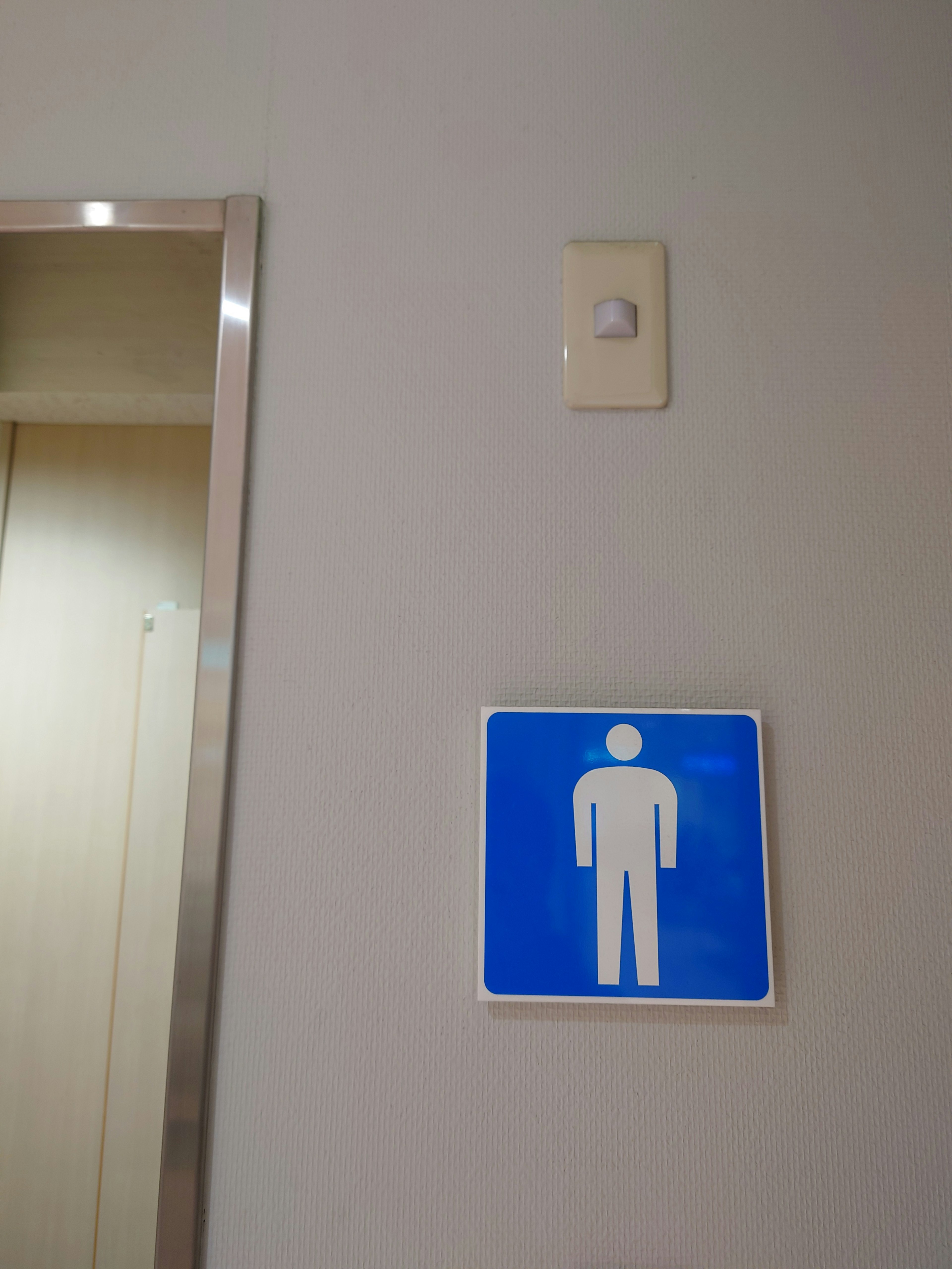 青い男性用トイレの標識が壁に取り付けられている