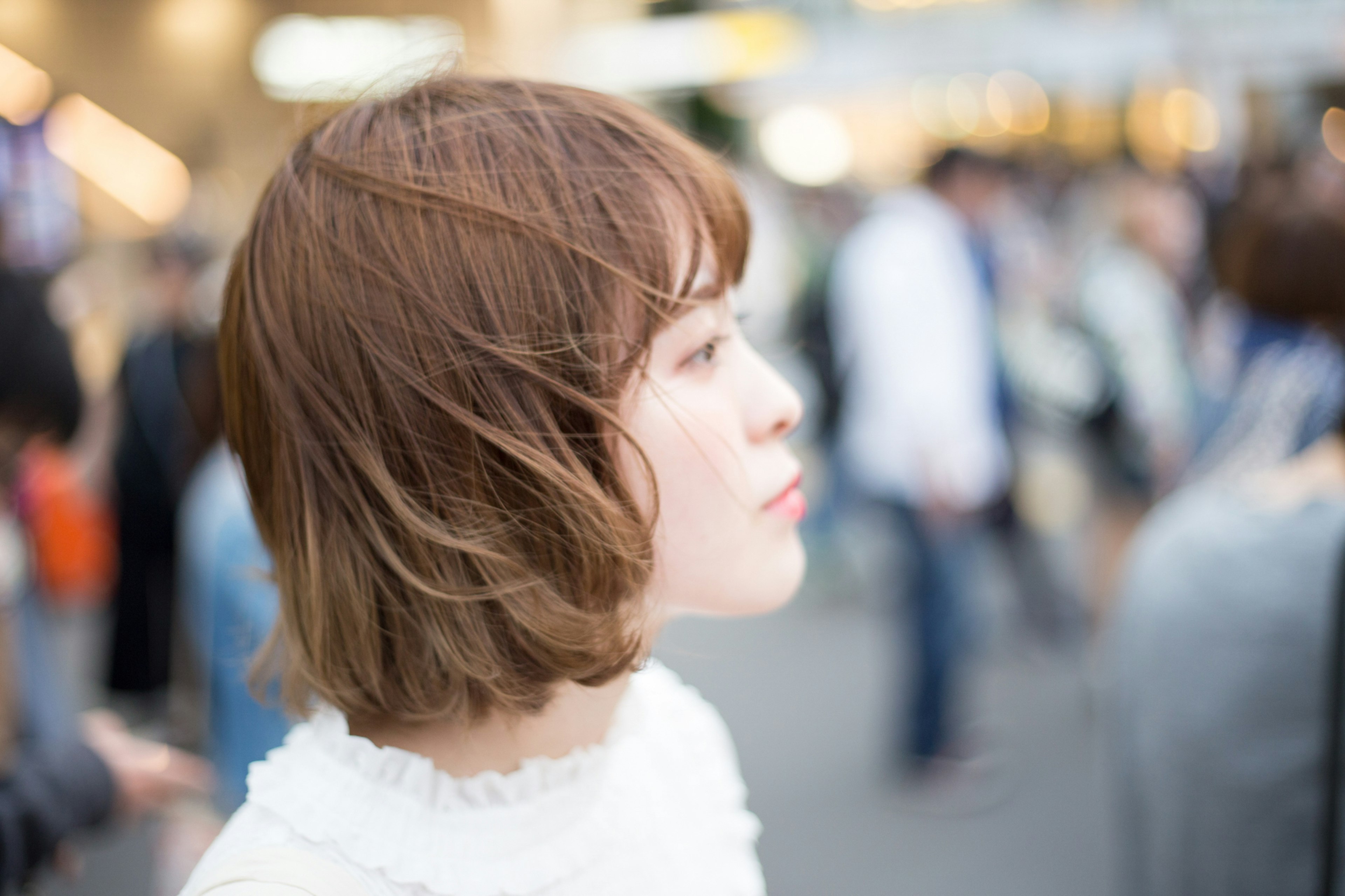 A woman with wind-swept hair standing in a busy street