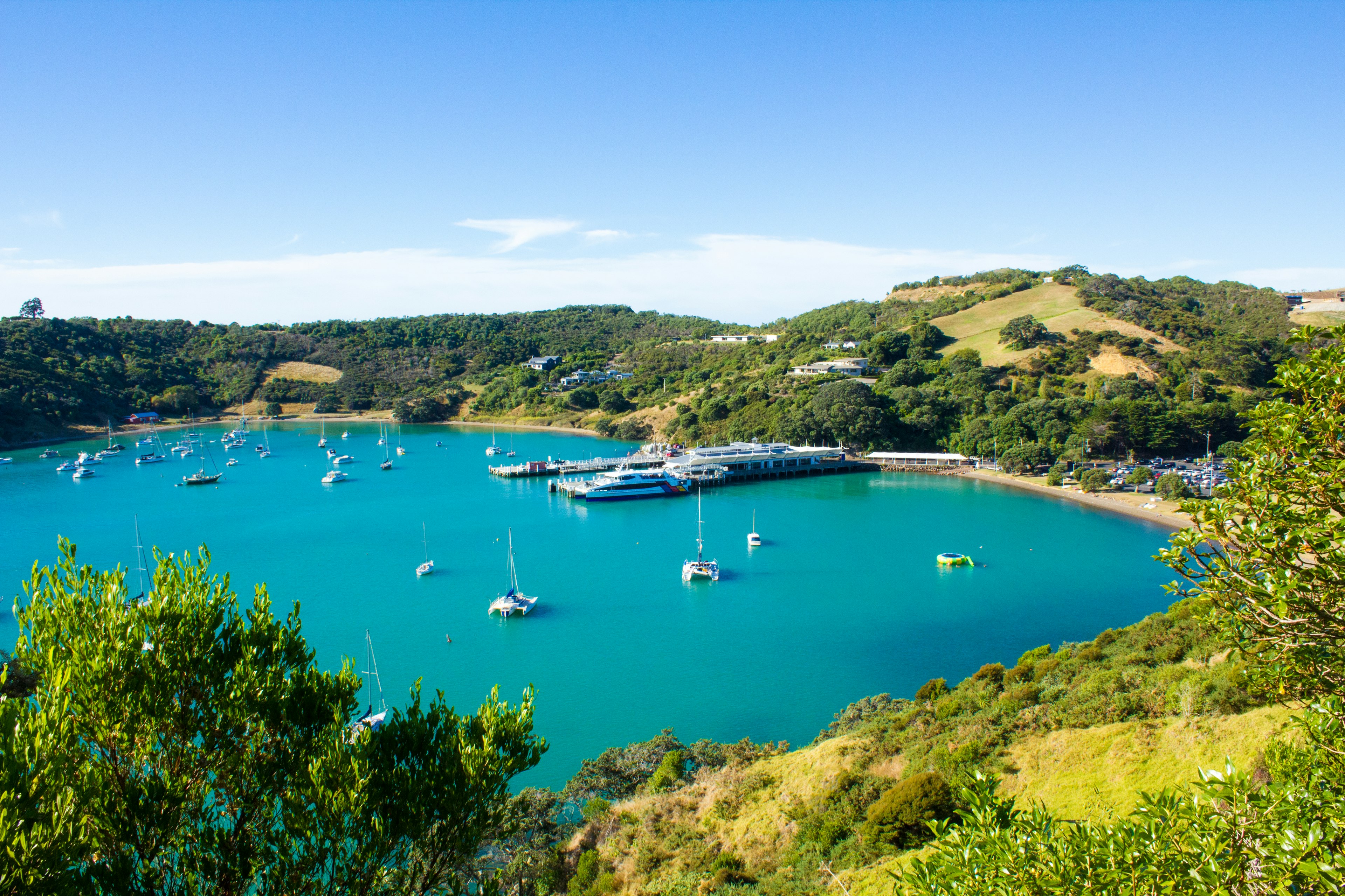 Malersiche Aussicht auf eine Bucht mit vor Anker liegenden Yachten und türkisfarbenem Wasser