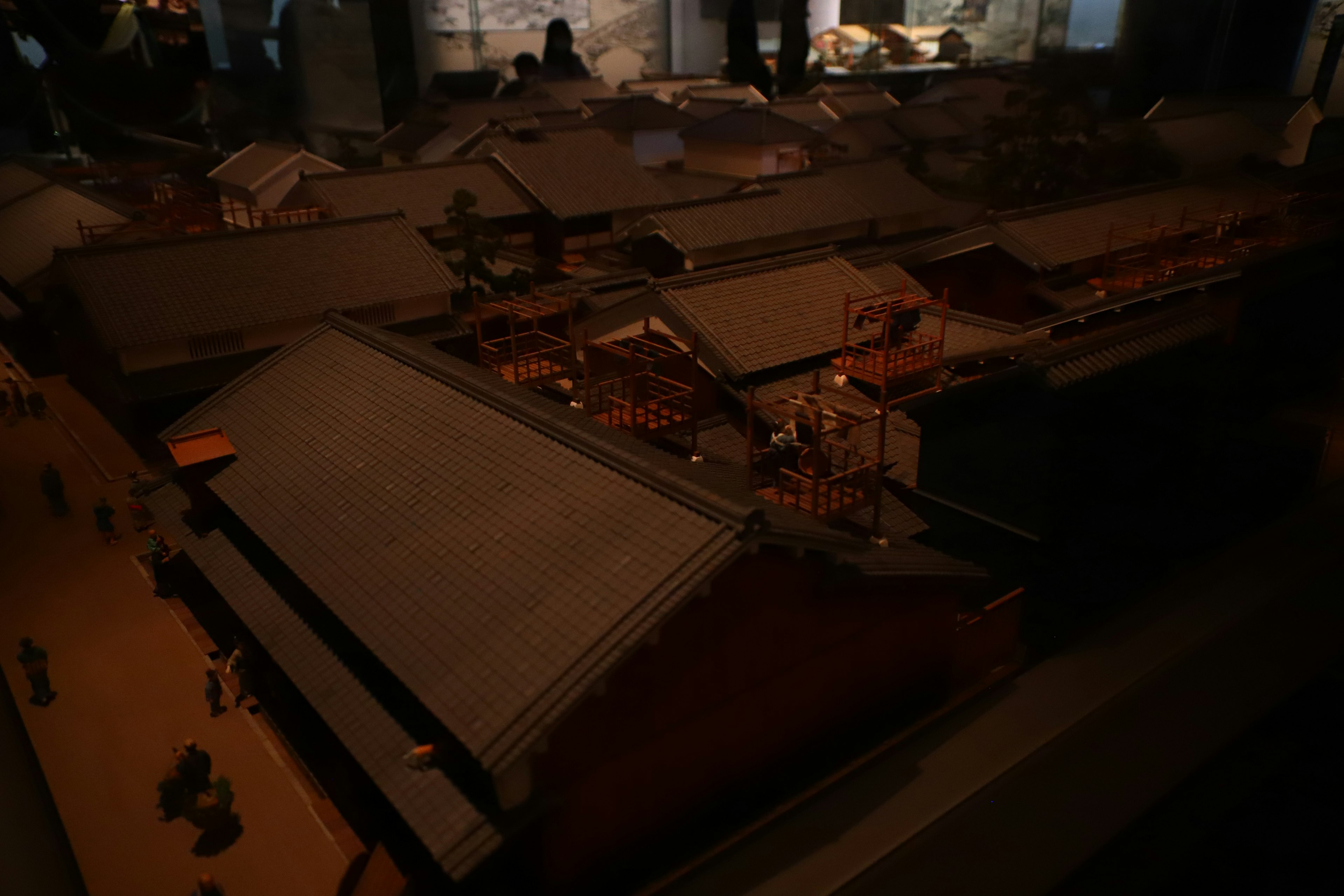 Detailed model of traditional buildings with visible roofs and people nearby