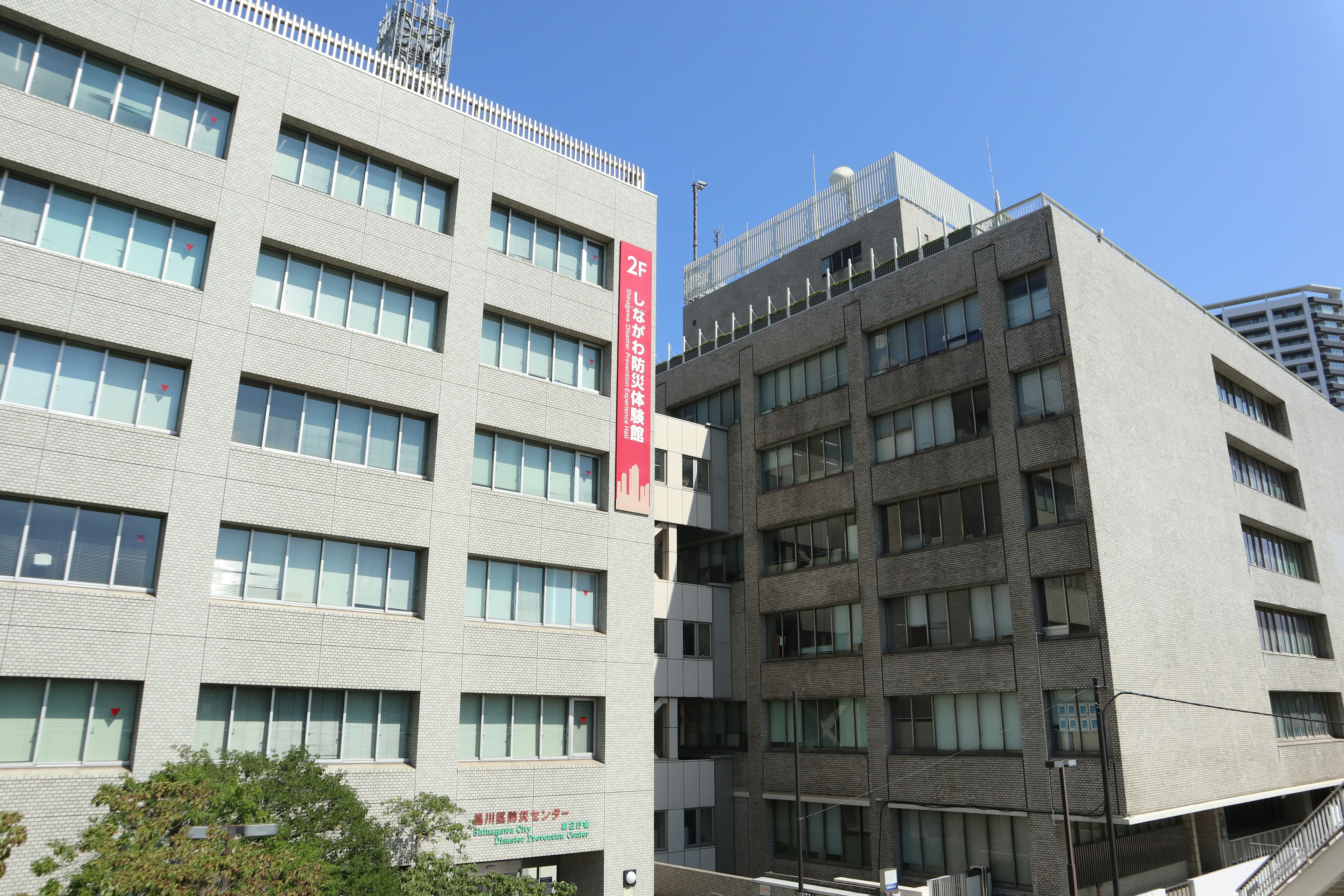 Zwei moderne Gebäude nebeneinander unter einem klaren blauen Himmel